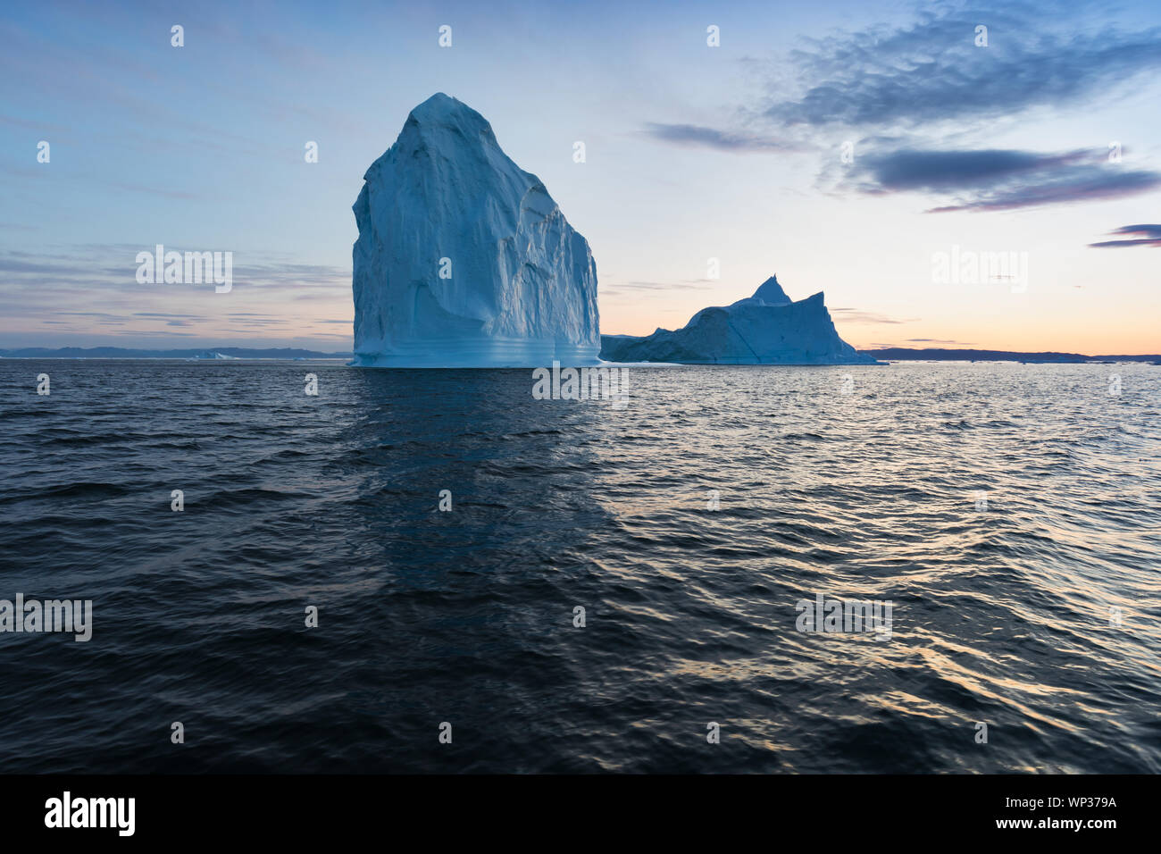 Icebergs in front of the fishing town Ilulissat in Greenland. Nature and landscapes of Greenland. Travel on the vessel among ices. Seascape Stock Photo