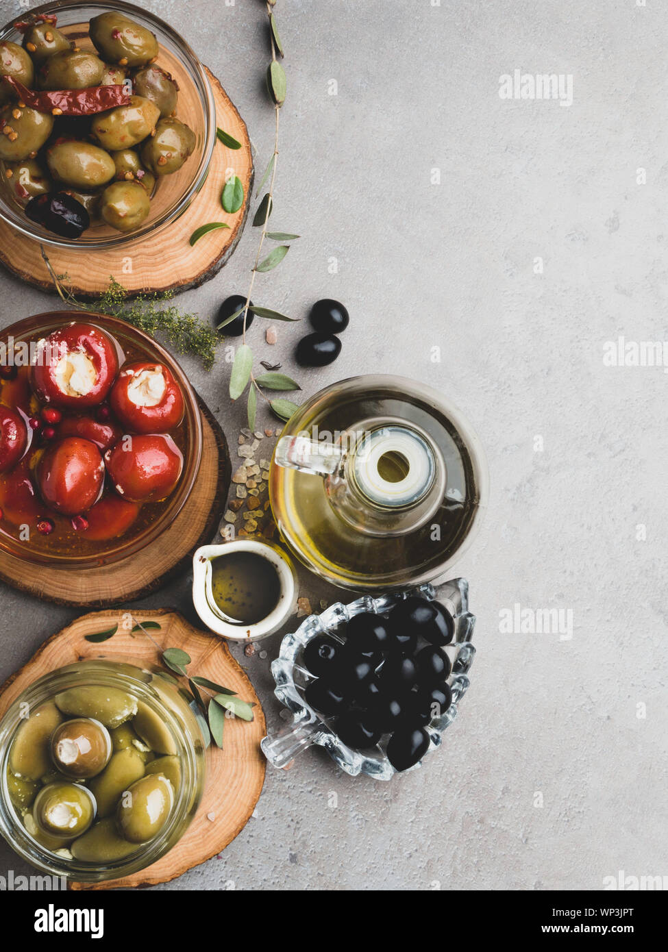 Italian food background, with bell peppers and green olives, stuffed with cheese, black olives, olive oil on wooden background. Stock Photo