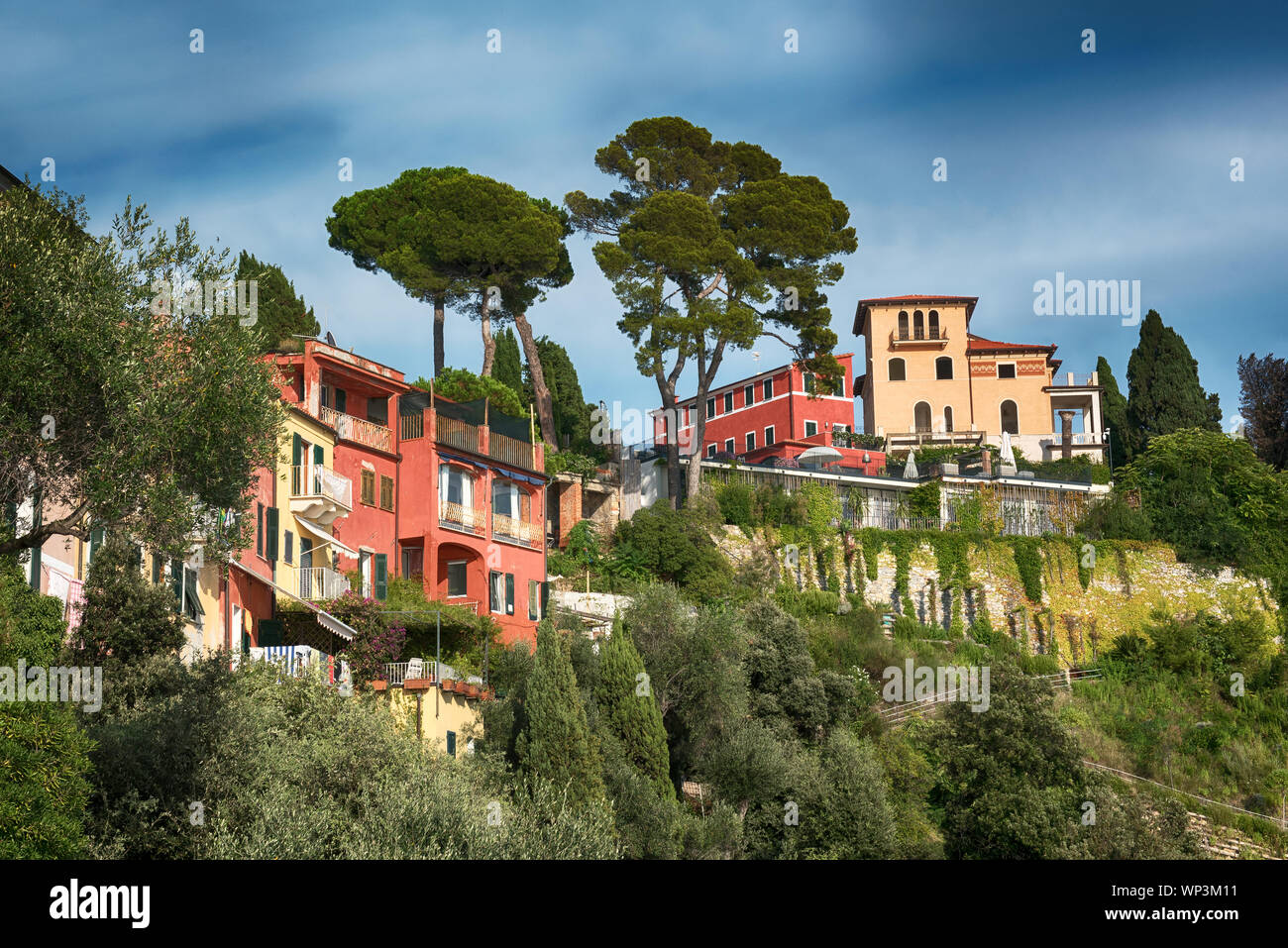 Colorful luxury villas in Lerici, Liguria, Italy on a steep cliff overlooking the Gulf of La Spezia viewed from below against a blue sky Stock Photo
