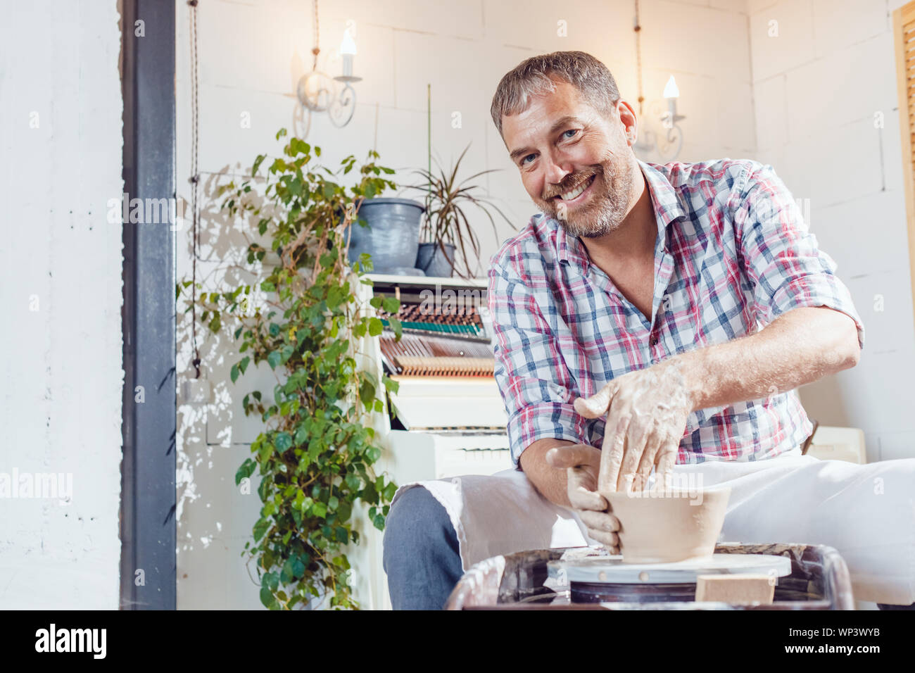 A male potter works on a pottery wheel in a workshop Stock Photo - Alamy