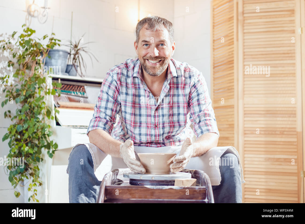 A male potter works on a pottery wheel in a workshop Stock Photo - Alamy