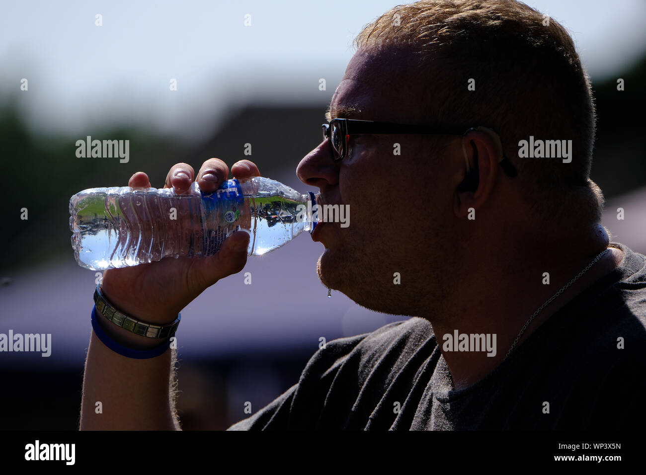 Motor bike enthusiast with drink n hot day at biker event. Stock Photo