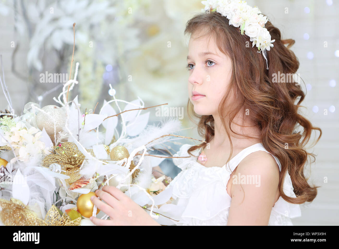 Beautiful girl in a white dress and a wreath Stock Photo - Alamy
