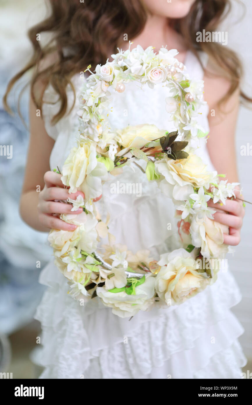 Beautiful girl in a white dress and a wreath Stock Photo - Alamy