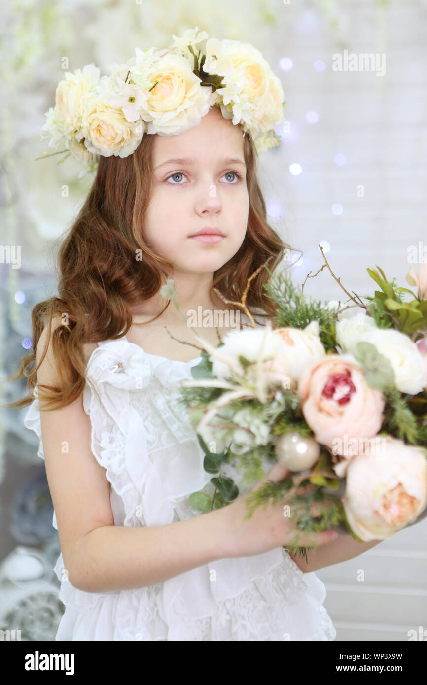 Beautiful girl in a white dress and a wreath Stock Photo - Alamy