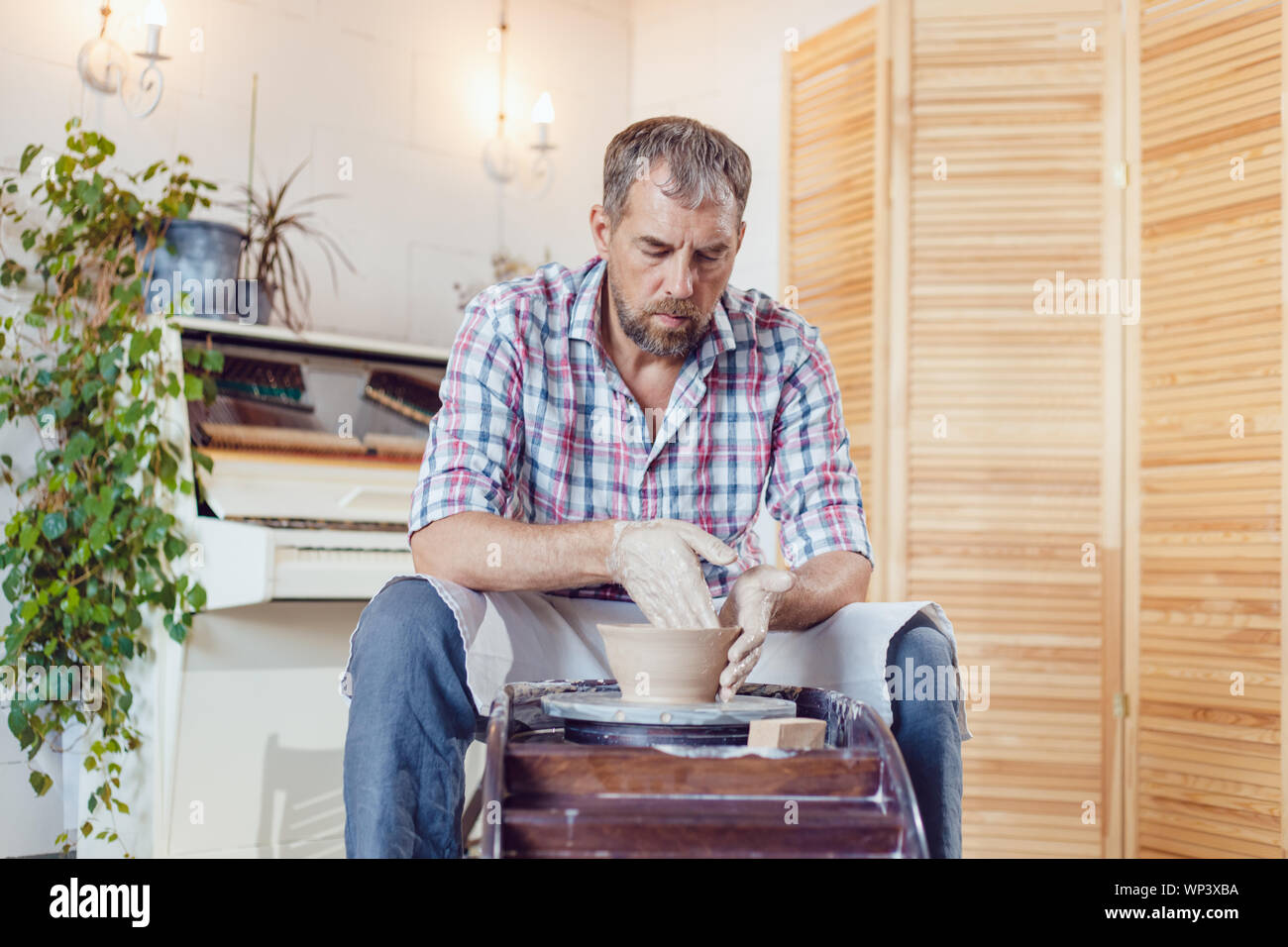 A male potter works on a pottery wheel in a workshop Stock Photo - Alamy