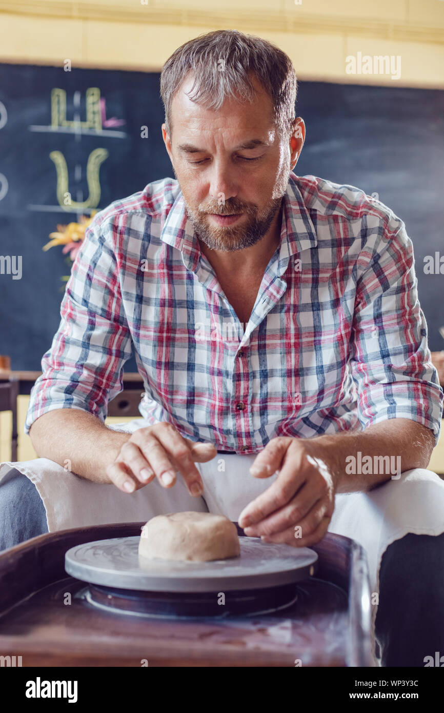 A male potter works on a pottery wheel in a workshop Stock Photo - Alamy