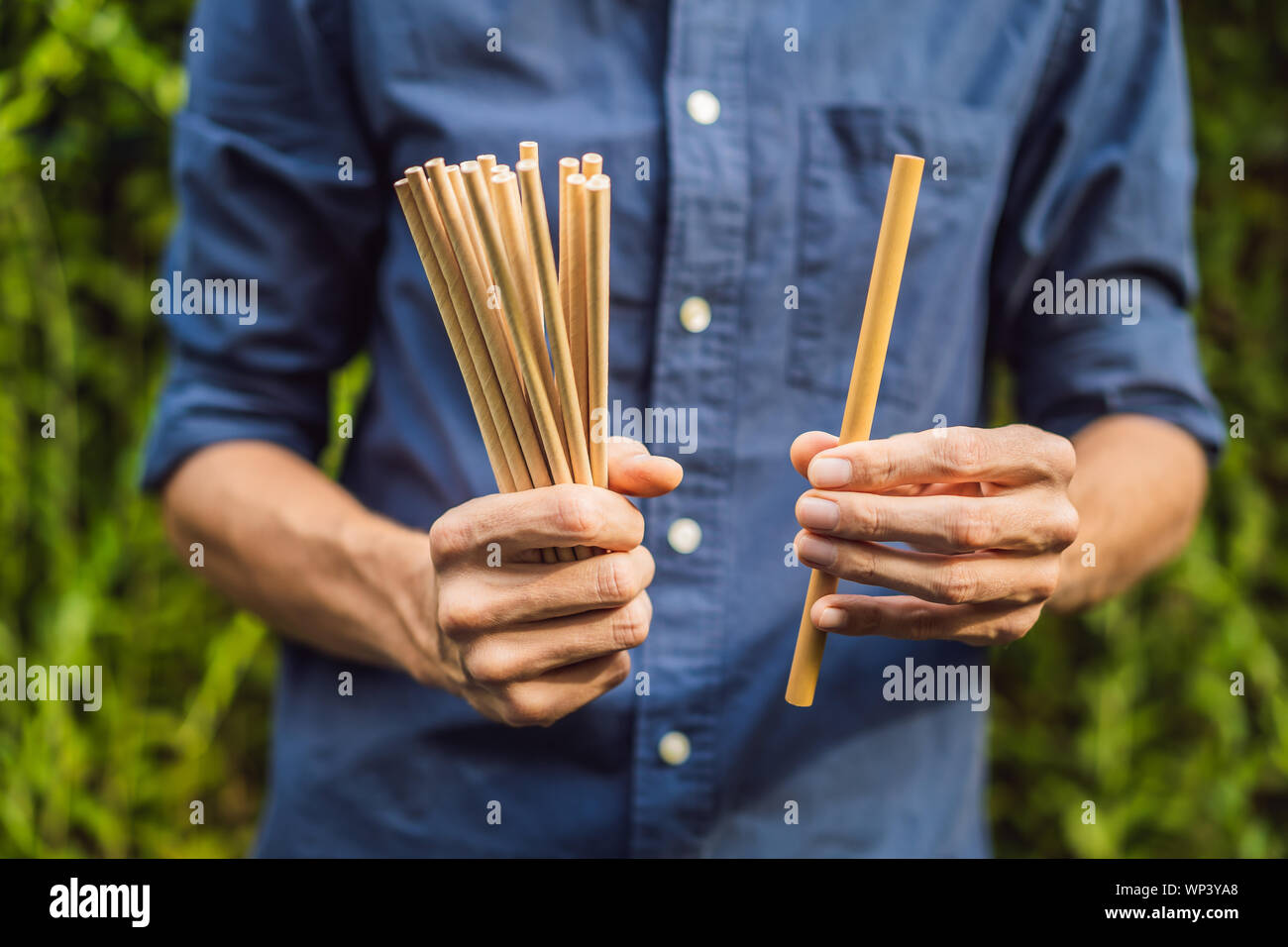 Bamboo drinking straw vs disposable straws in hands. Zero waste concept