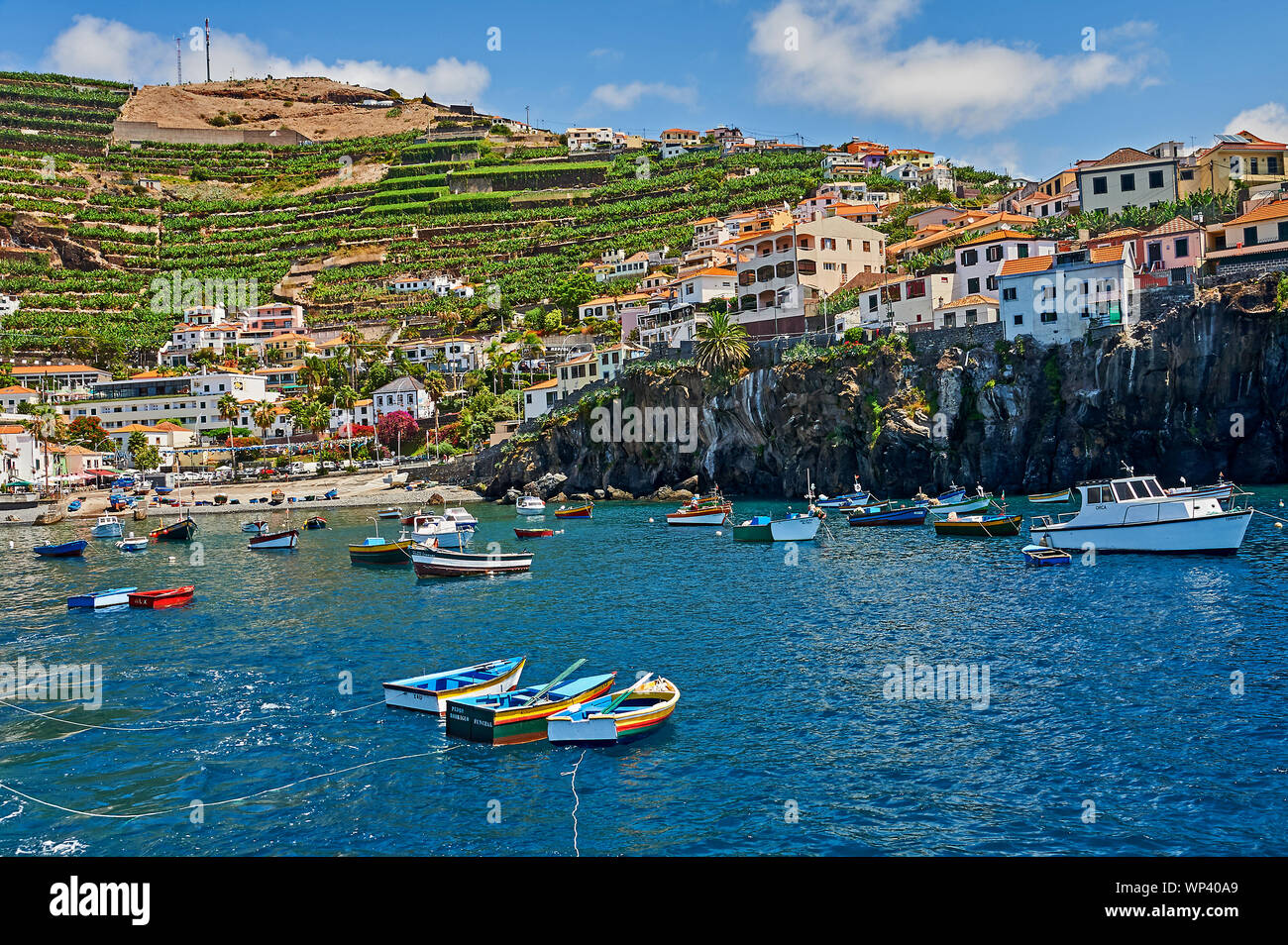 The island of Madeira and the village of Camara de Lobos, and fishing boats in the pretty harbour, are overlooked by terraced hillsides. Stock Photo