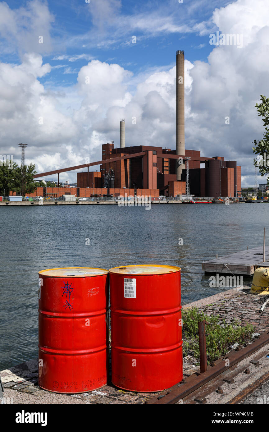 Red oil drums on Sompasaari quay, Hanasaari Power Plant in background, in Helsinki, Finland Stock Photo