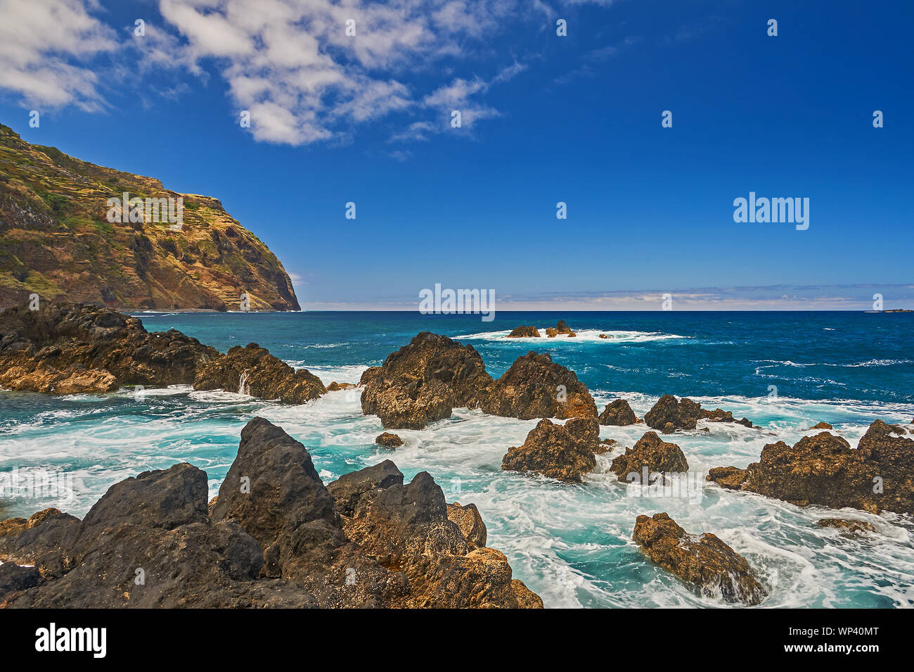 Atlantic Ocean and rugged volcanic coastline of northern Madeira at Porto Moniz, with waves breaking on rocks and shoreline. Stock Photo