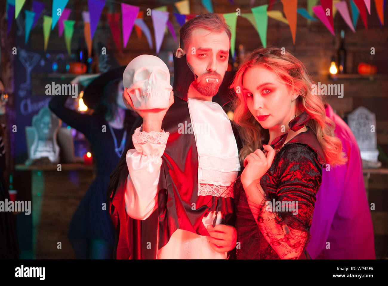 Portarit of good friends dressed up for halloween celebration. Man in Dracula costume. Stock Photo