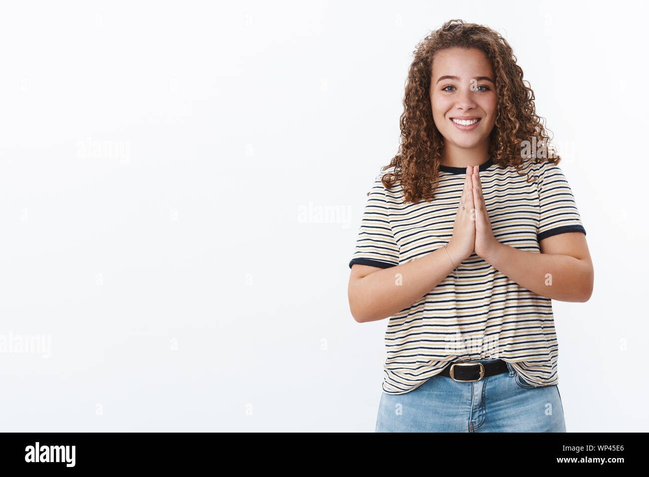 God hear us. Charming hopeful happy relieved young chubby curly-haired ...