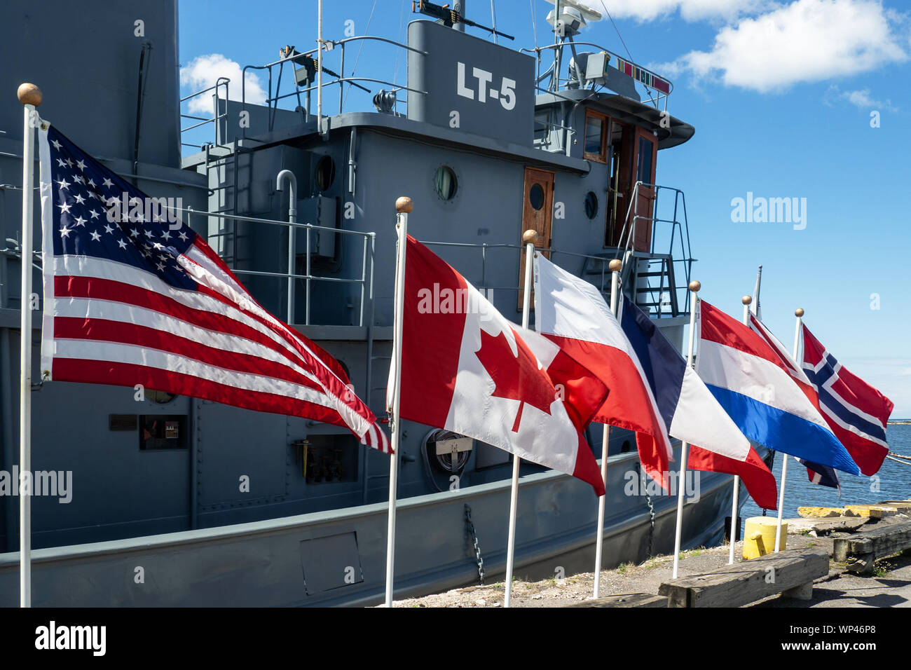 Oswego, New York, USA. September 6, 2019. Country flags in front of  the World War II tug boat the LT-5 on display at the H. Lee White Maritime Museum Stock Photo