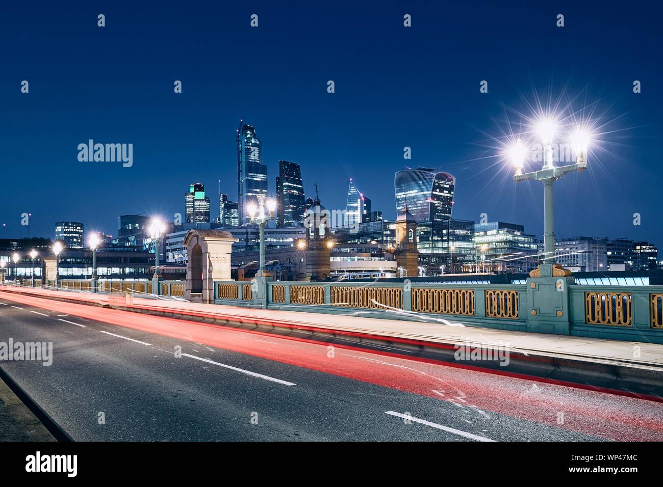 Light trail of car on bridge against illuminated urban skyline. London, United Kingdom Stock Photo