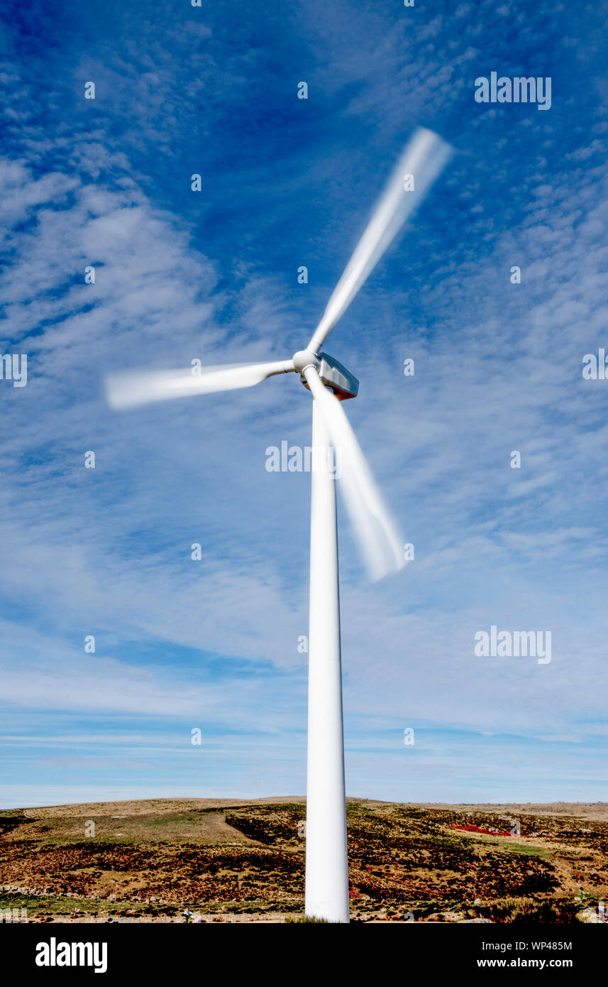 Spinning wind turbine  in the mountains of central Spain on a cold, clear, sunny day in November Stock Photo