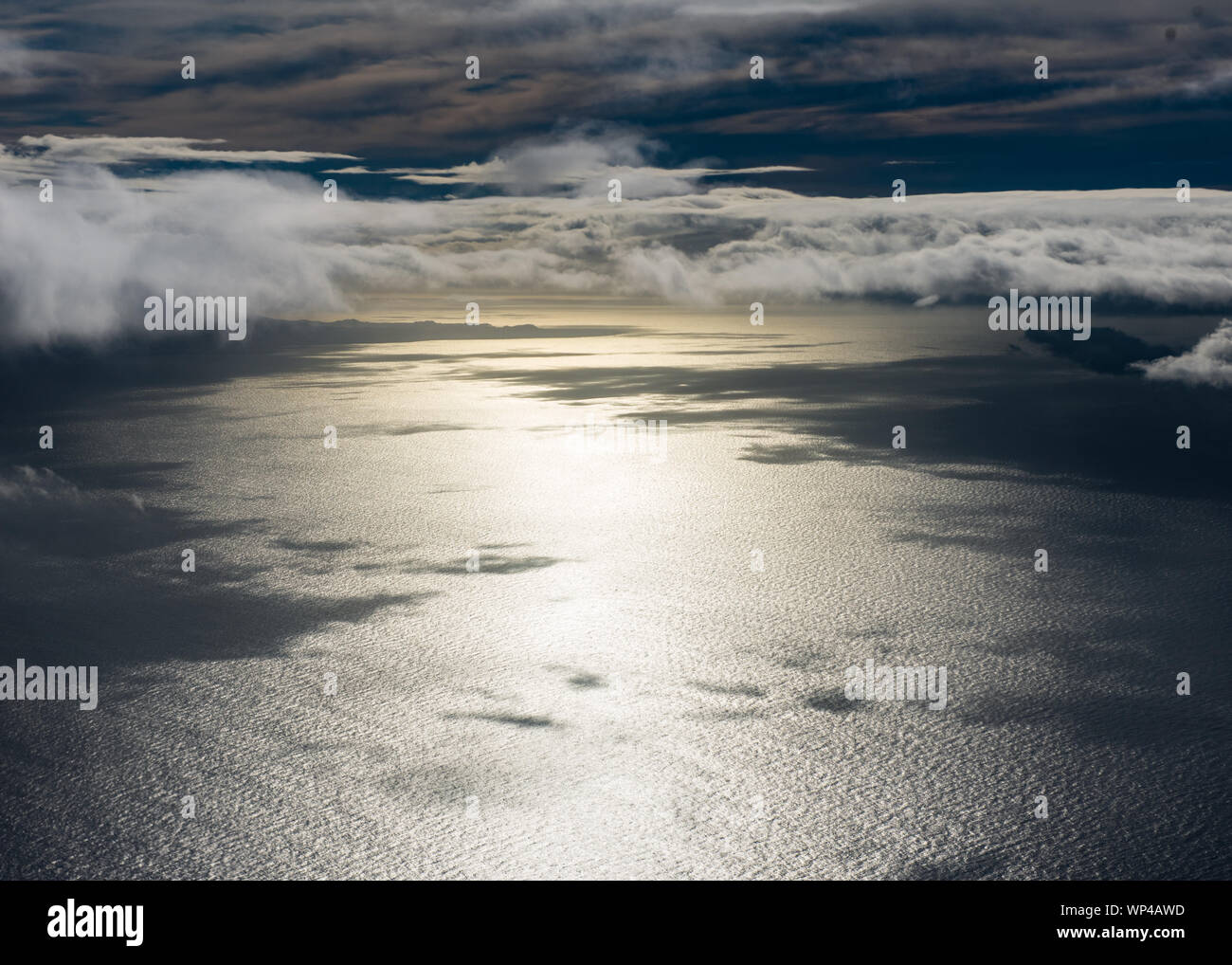 Arial view of dramatic cloudscape over the Atlantic Ocean close to Tenerife, Canary Islands with the sun reflecting from the sea with cloud shadows Stock Photo