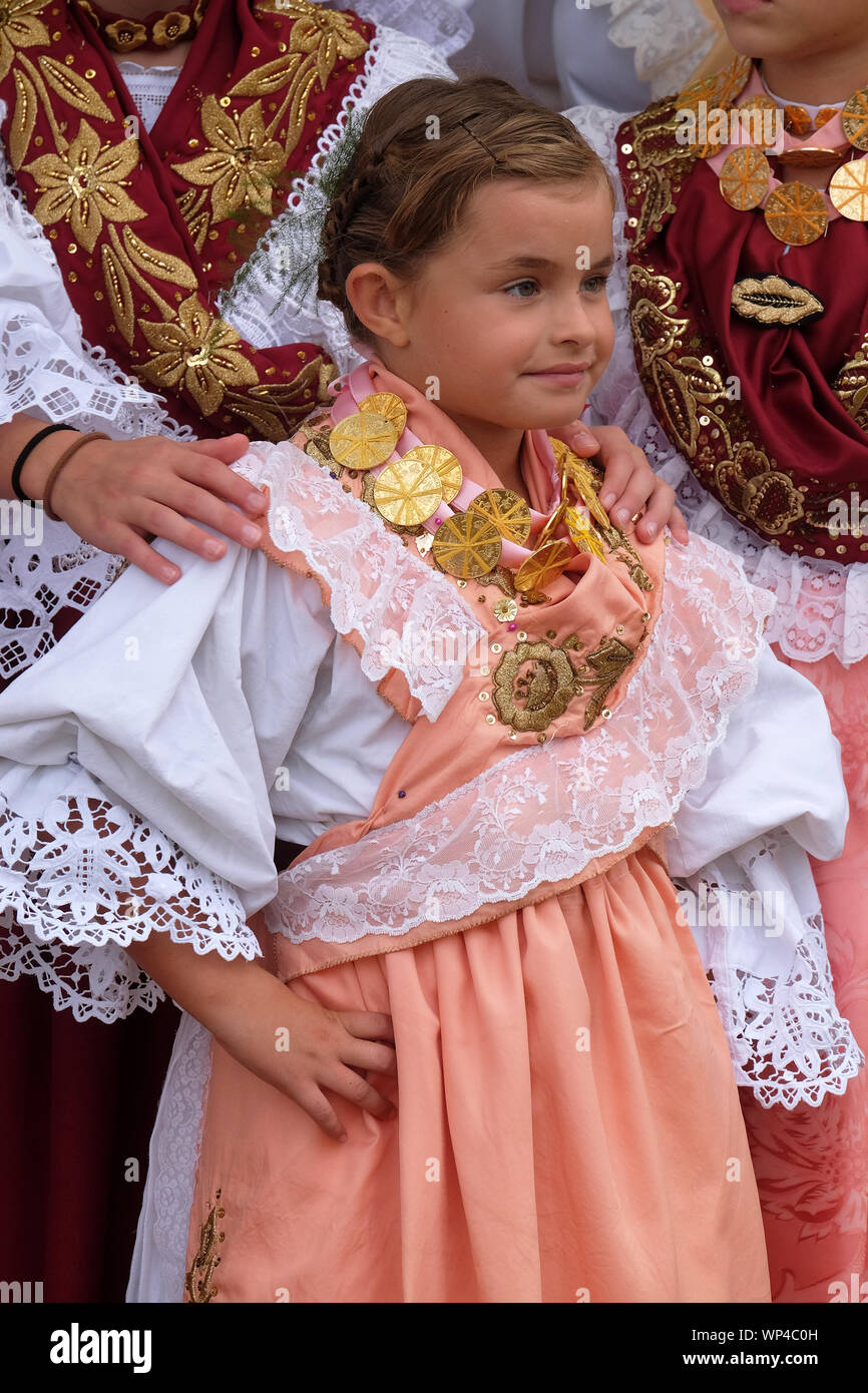 Girl dressed in folk costumes go to the church at the Mass on Thanksgiving day in Stitar, Croatia Stock Photo