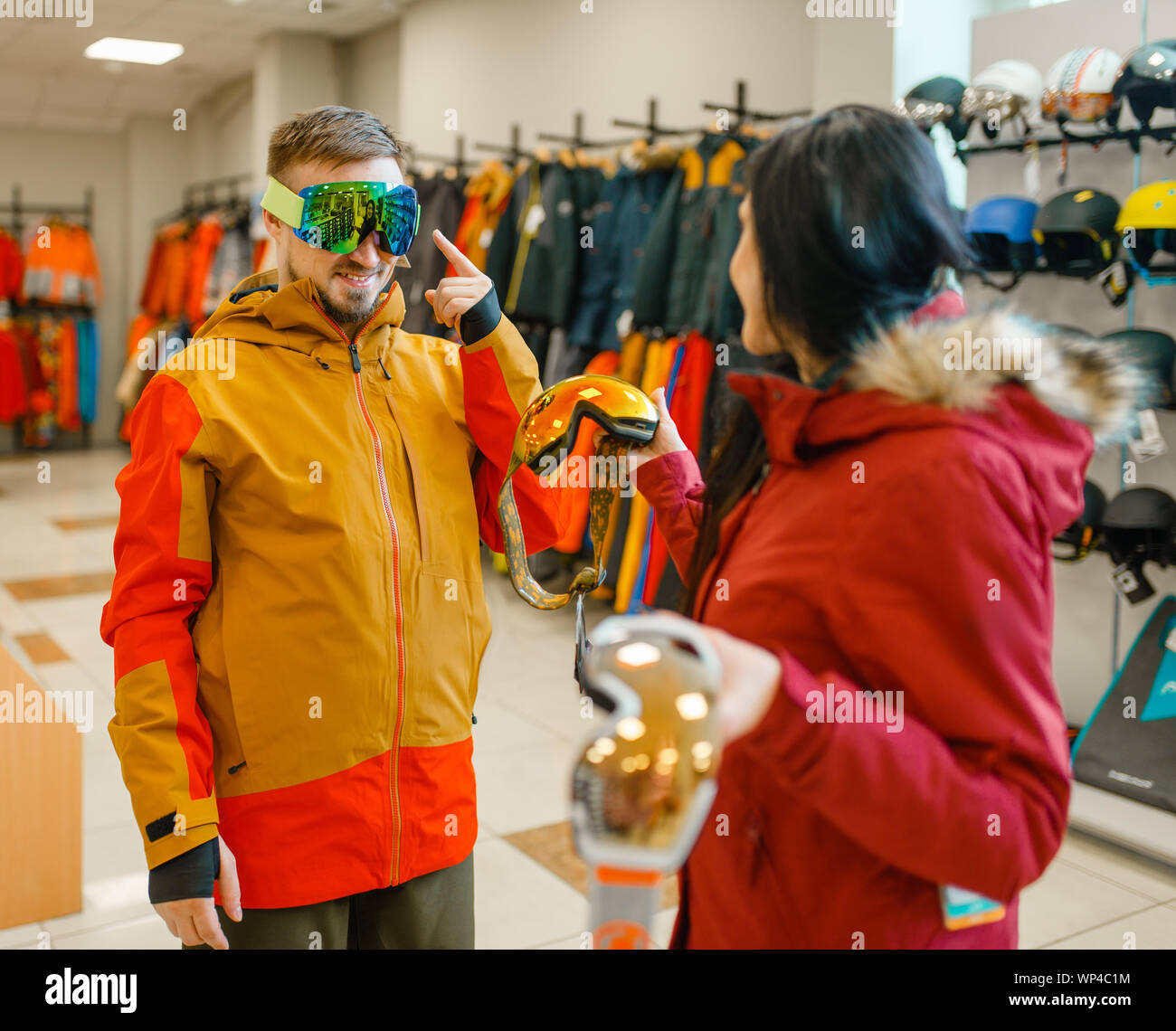 Couple trying on mask for ski or snowboarding Stock Photo