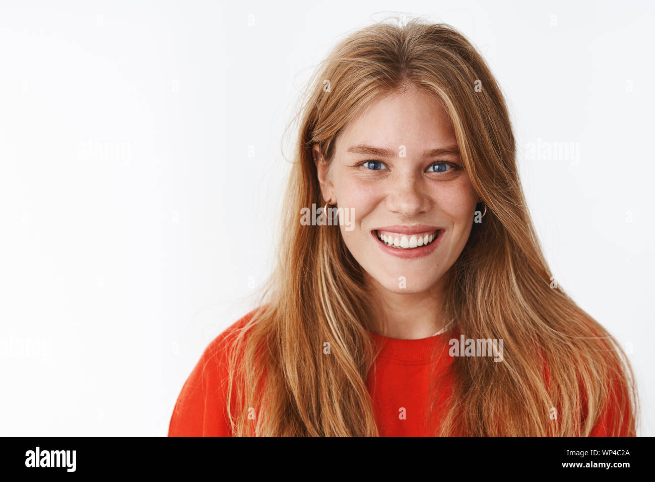 Close-up shot of happy charismatic good-looking young woman with chubby cheeks and white pleasant smile looking at camera joyfully with entertained an Stock Photo