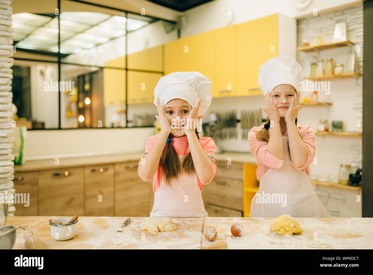 Little girls chefs smears their faces with flour Stock Photo - Alamy