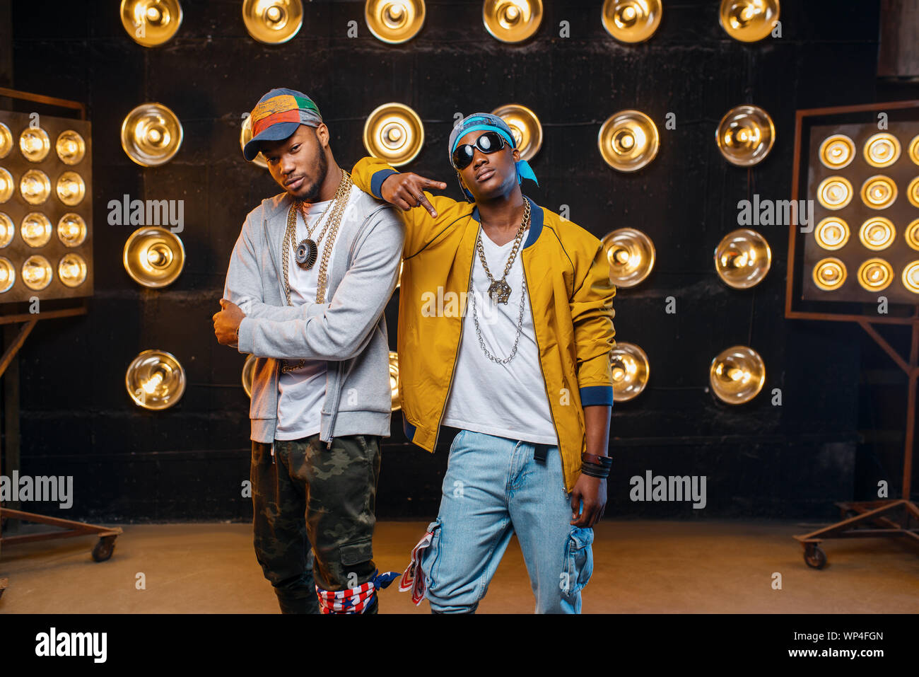 Two black rappers in caps, artists poses on stage Stock Photo Alamy