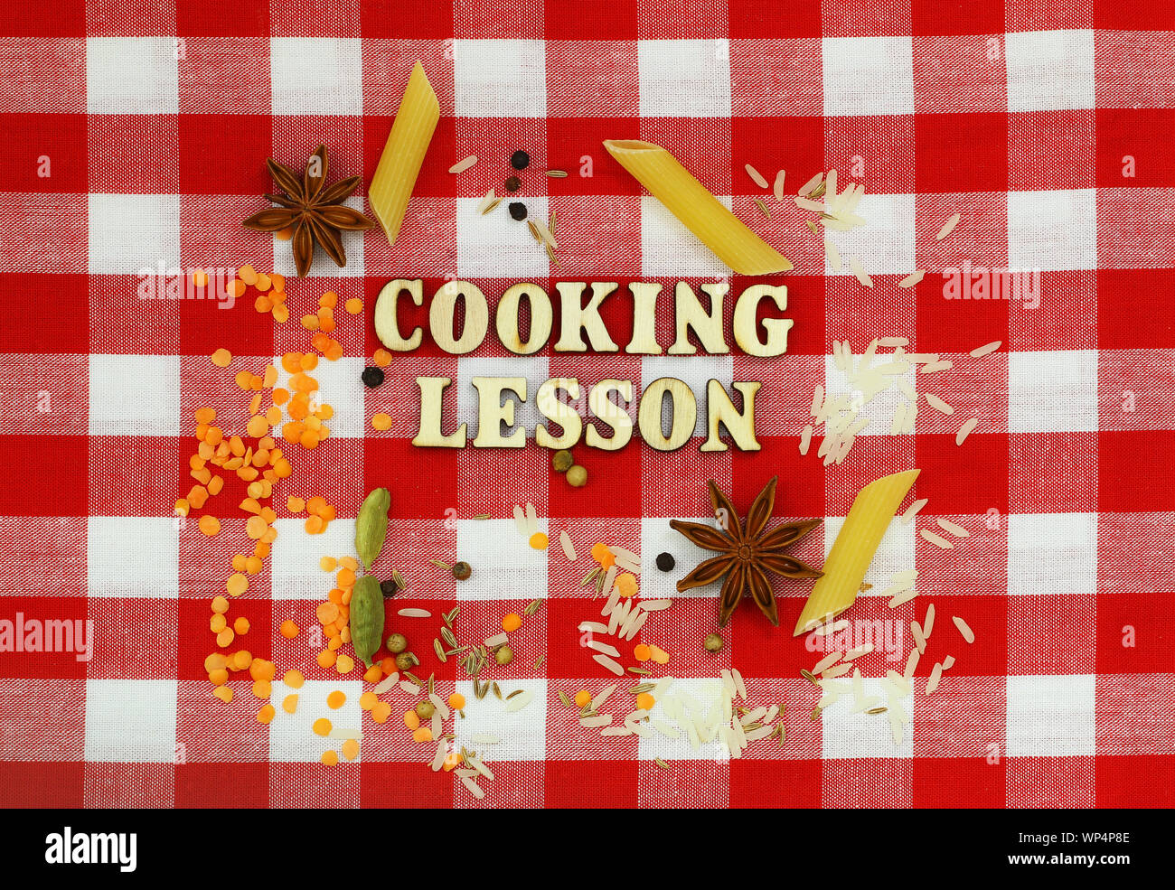 Cooking lesson written with wooden letters on checkered cloth and cooking ingredients Stock Photo