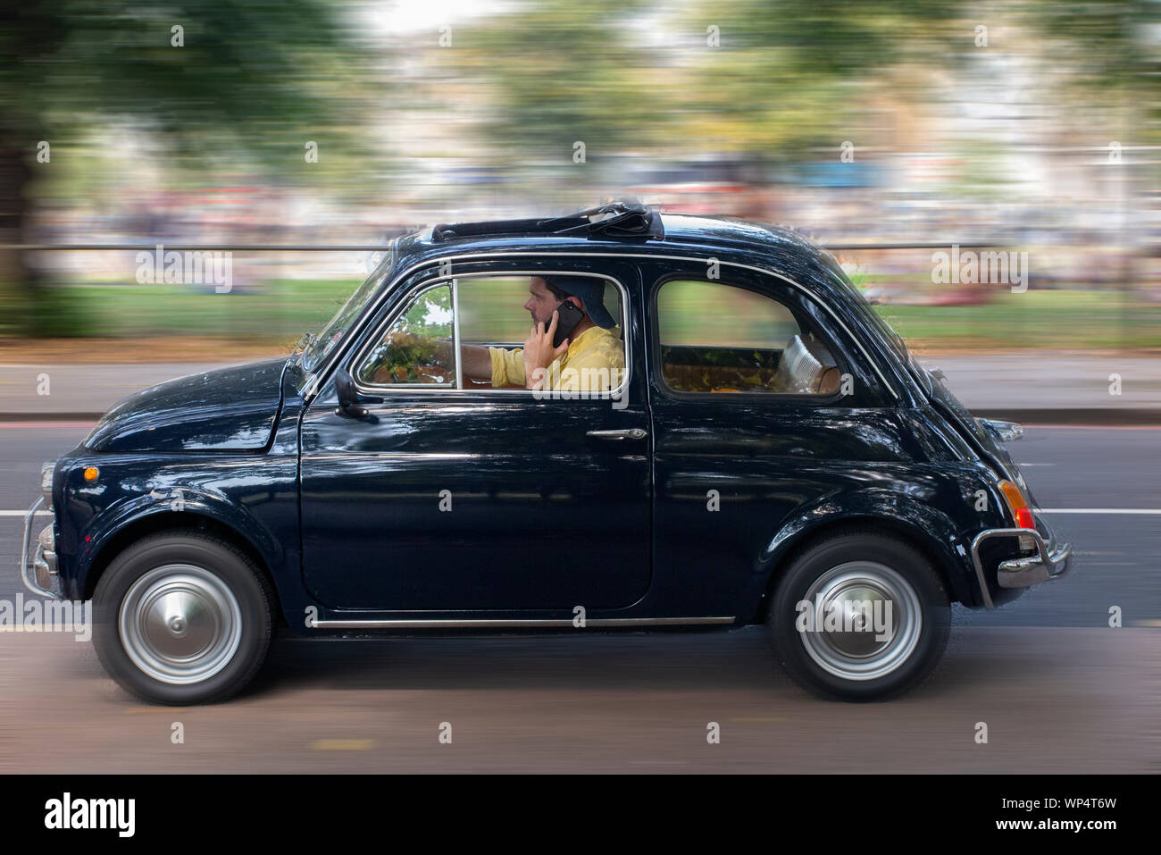 A Man Drives His Vintage Fiat 500 Whilst On The Phone Stock Photo Alamy