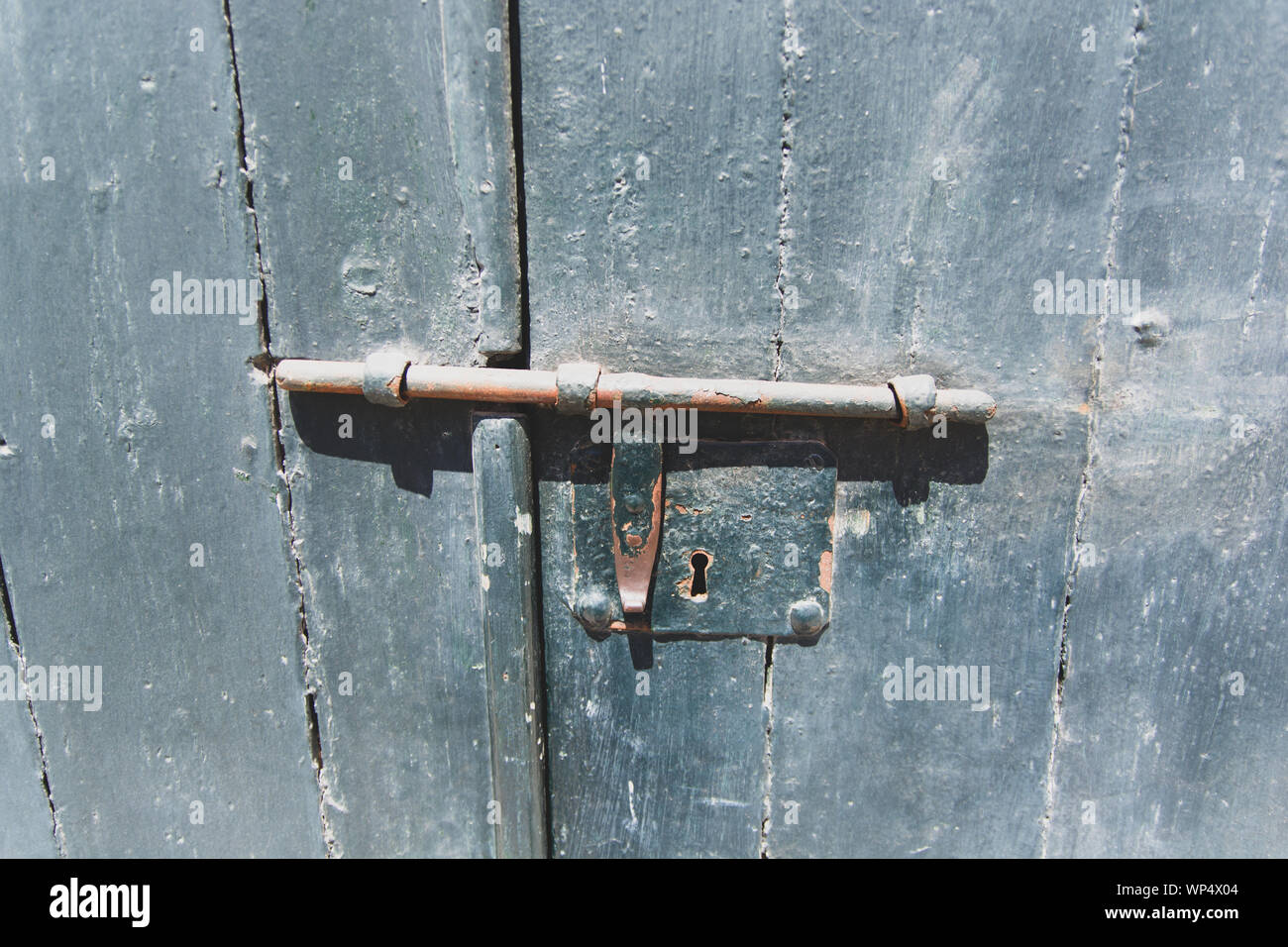 Rusty old slide bolt or tower bolt on a worn green door Stock Photo - Alamy