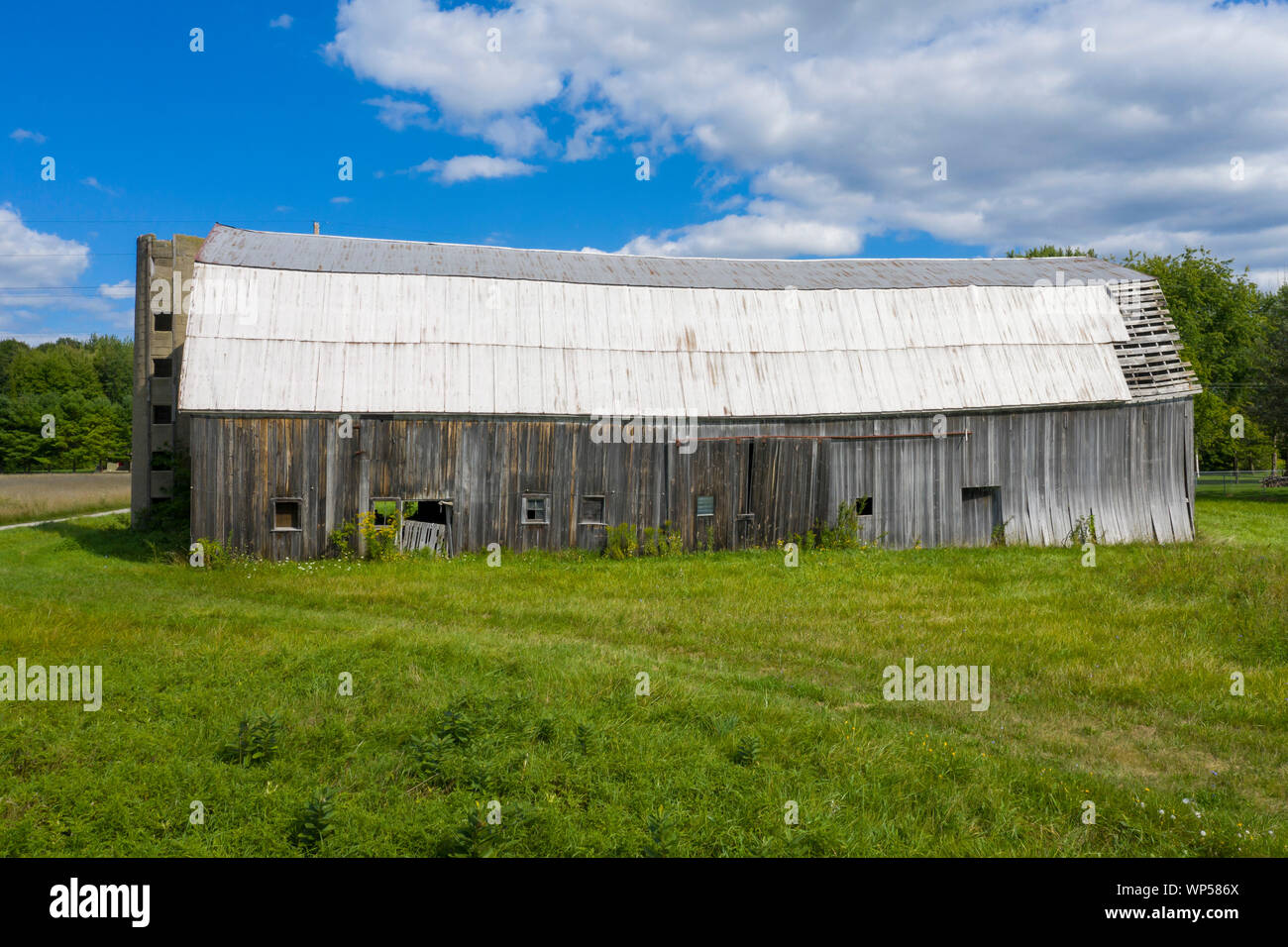 Adair, Michigan - An old, decrepit barn with the remains of a concrete silo. Stock Photo