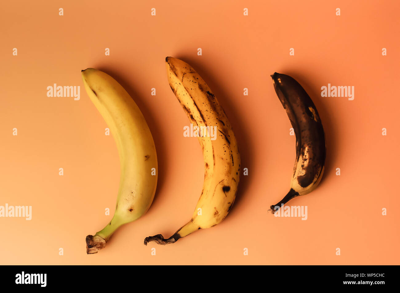 Ugly fruit modification of three bananas from ripe to more spoiled brown with spots isolated. The concept of fruit is not salable for supermarkets Stock Photo