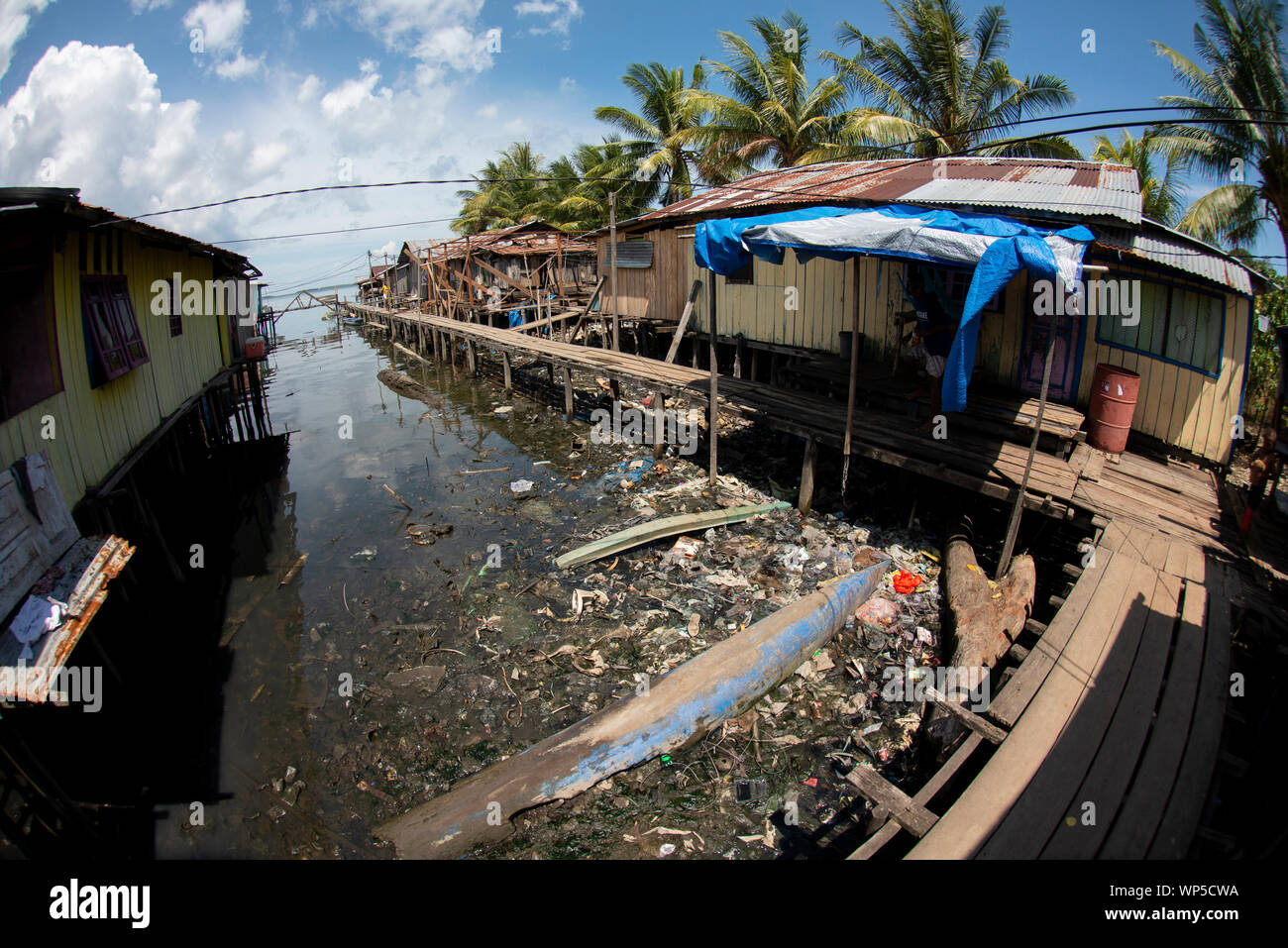 Shacks and walkway surrounded by garbage, Sorong, West Papua, Indonesia Stock Photo