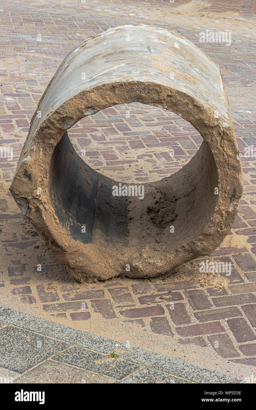 part of an old concrete sewer pipe lying on the street Stock Photo