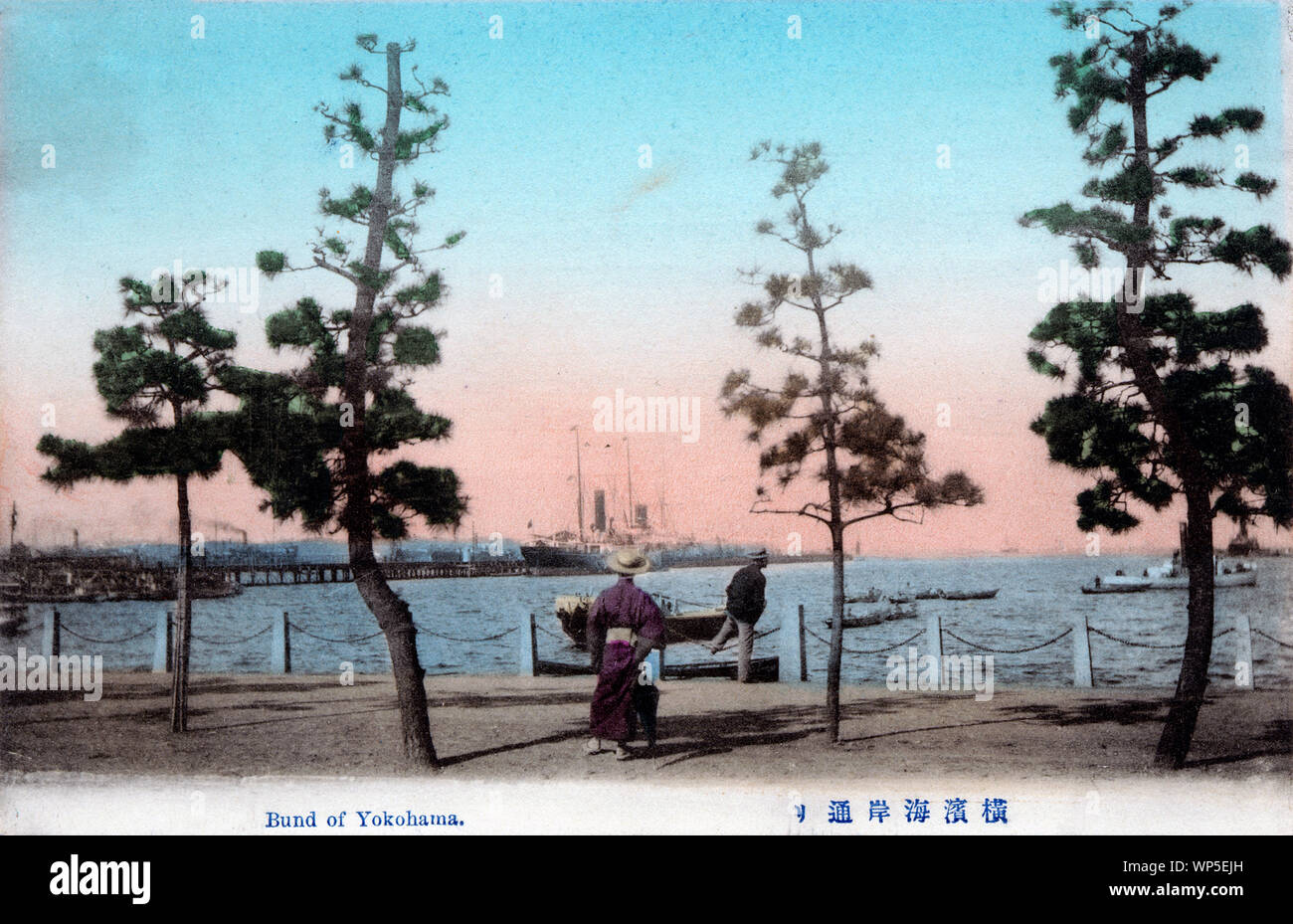 [ 1910s Japan - Yokohama Harbor ] —   View of Yokohama Harbor from the Bund in Yokohama, Kanagawa Prefecture. Two men wearing straw hats are observing harbor activities.  20th century vintage postcard. Stock Photo