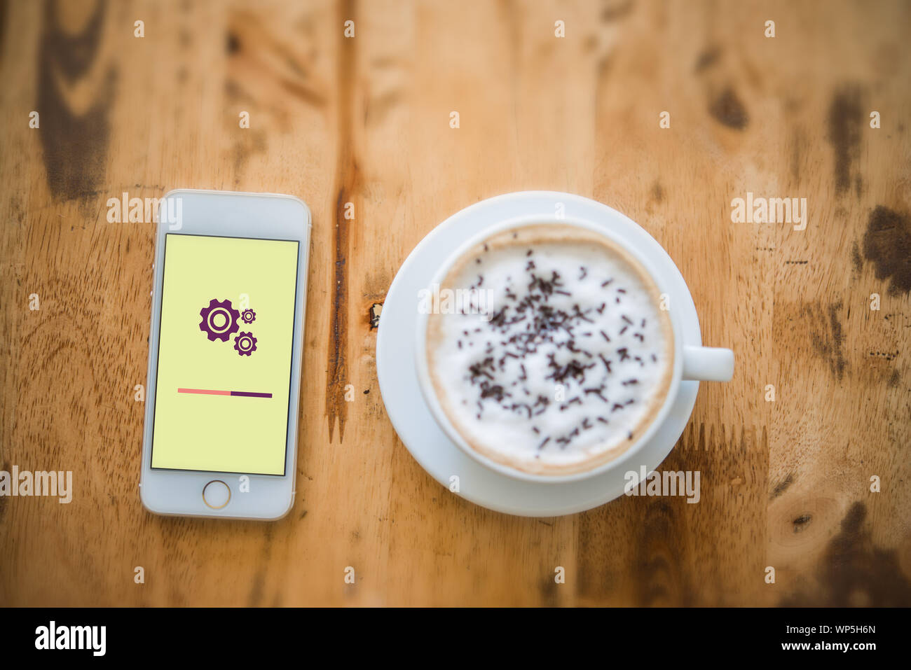 close-up top view of setting screen on mobile phone with a cup of coffee beside. All screen graphics are made up. Stock Photo