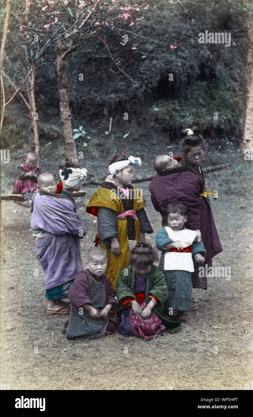 [ 1900s Japan - Japanese Child Nursemaids ] —   A group of komori on a country road.  Komori were young girls from poor families who were hired by the year to aid middle and upper class mothers in the care of their infant. In addition to carrying the baby around, the komori would also assist a little with the household work.  Komori received food, lodging, clothing, and occasionally some money.  20th century vintage postcard. Stock Photo