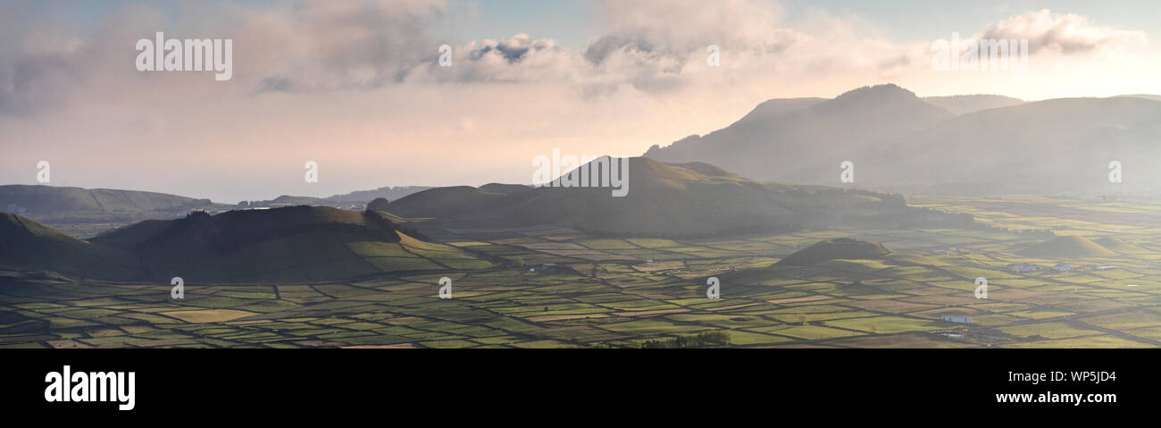 aerial sunset landscape on the amazing Serra do Cume and Serra da Ribeirinha volcanic craters and calderas covered with a pattern of walled fields on Stock Photo