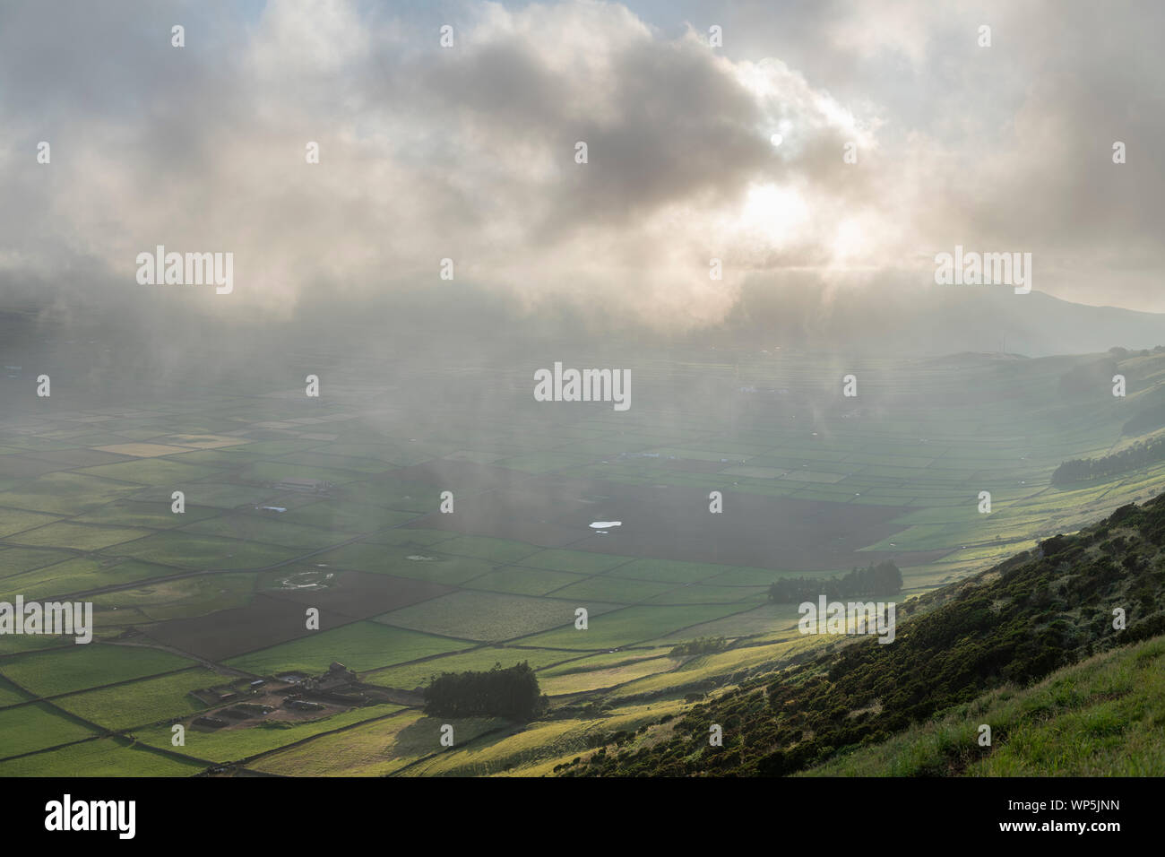 low clouds over the Miradouro da Serra do Cume revealing the typical plots with walls landscape of Terceira, Azores Stock Photo