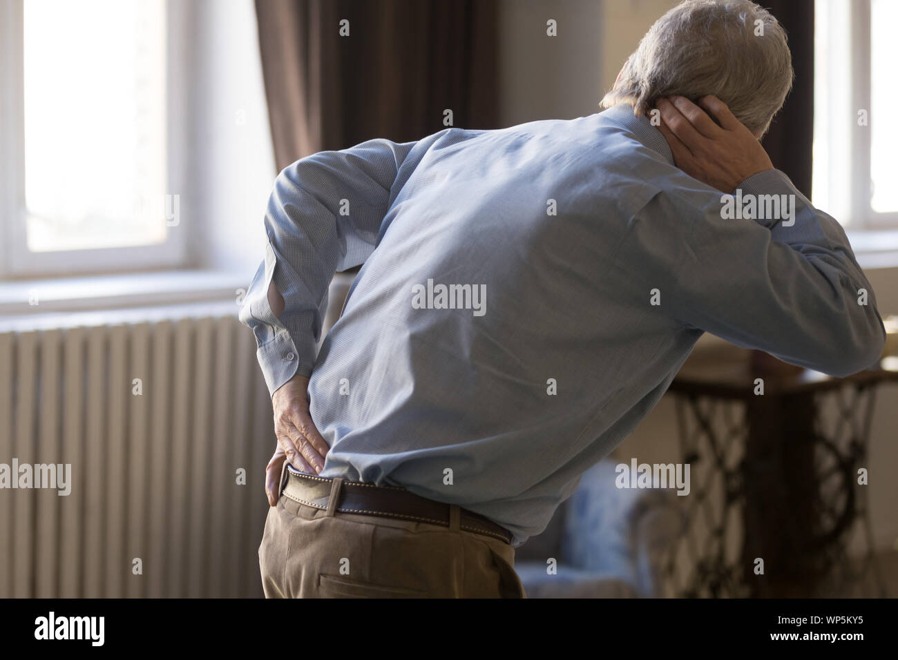Hurt senior man touch back suffering from rheumatism Stock Photo