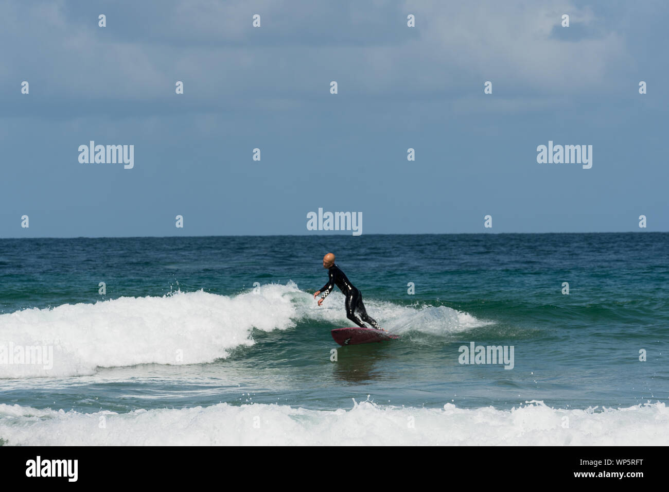 A young athletic man surfing waves in the Atlantic on the coast of Brittany on a summer day Stock Photo