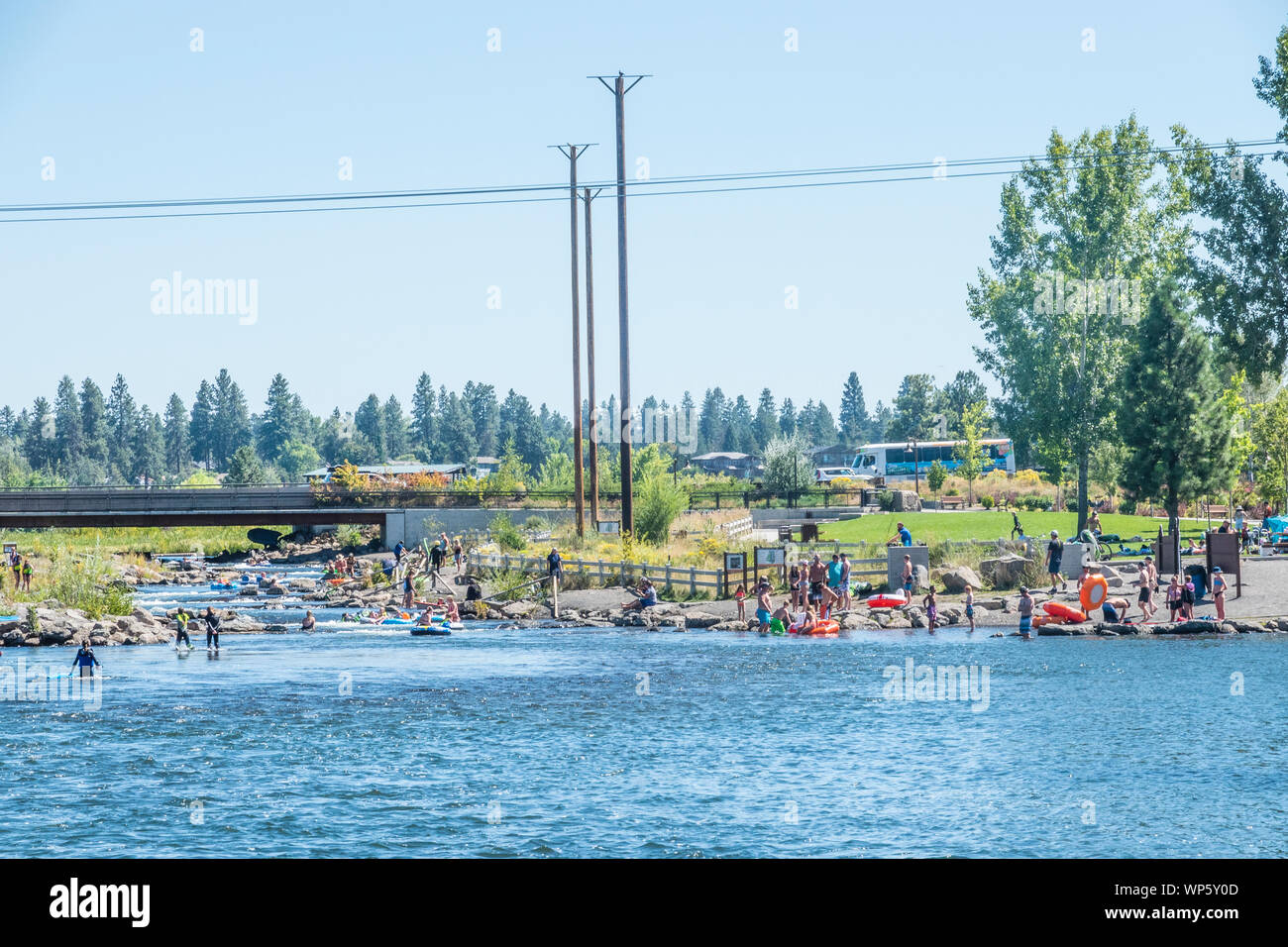 Tubers and swimmers at the Bend White Water Rapid Park on a hot summer day cooling off in the Deschutes River. Stock Photo