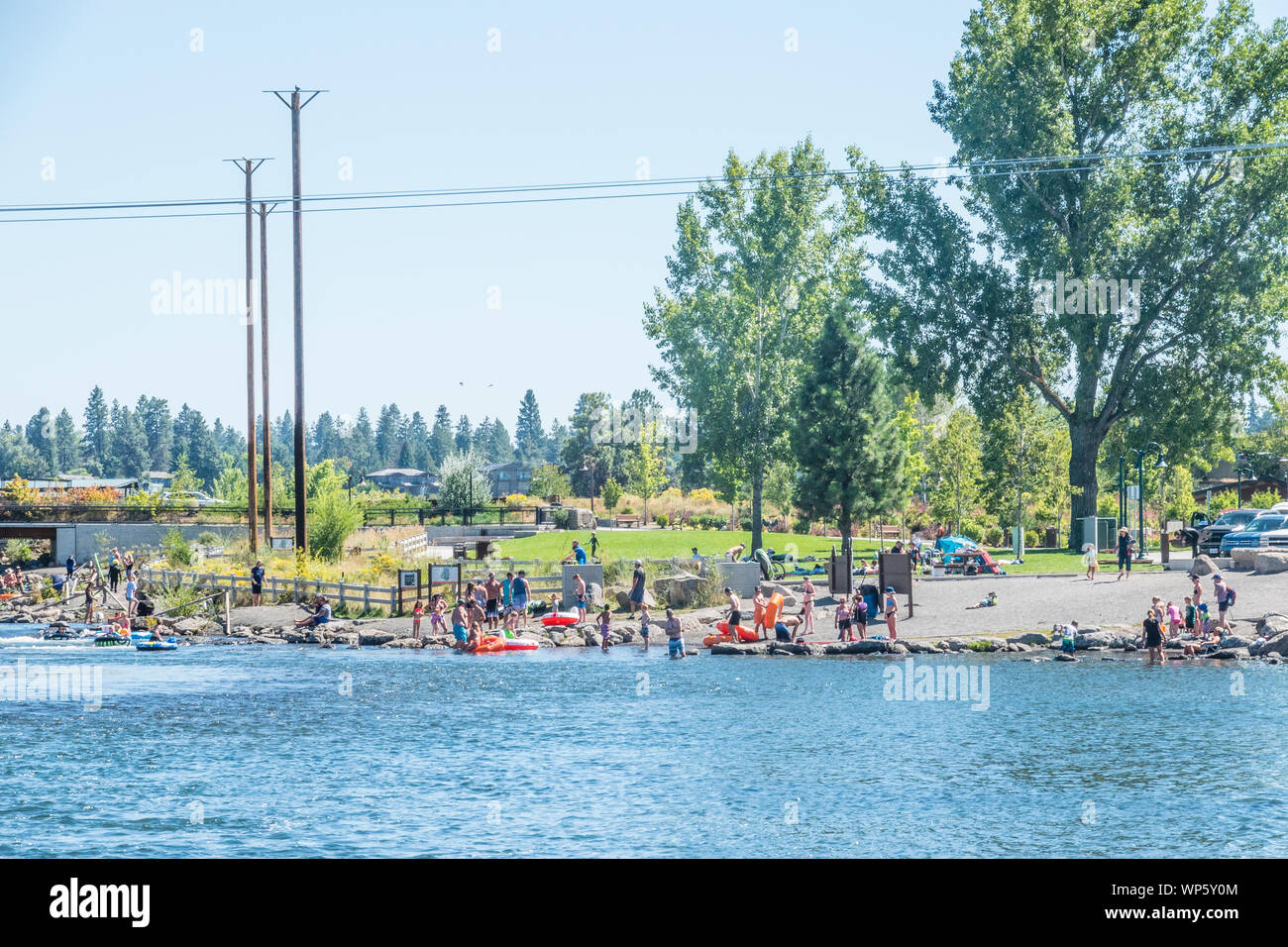 Tubers and swimmers at the Bend White Water Rapid Park on a hot summer day cooling off in the Deschutes River. Stock Photo
