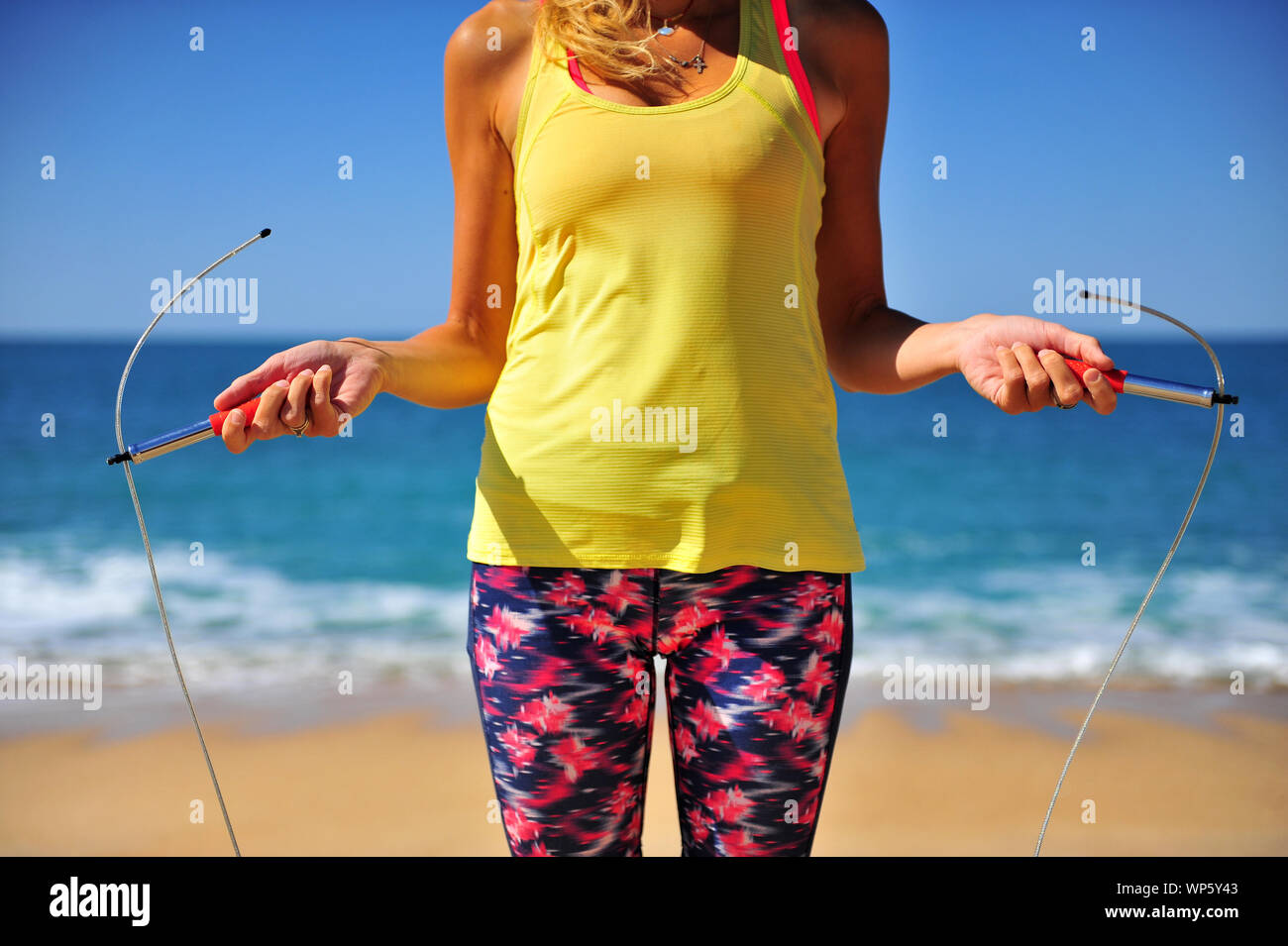 Athletic girl reasy for jumping on the sand beach Stock Photo