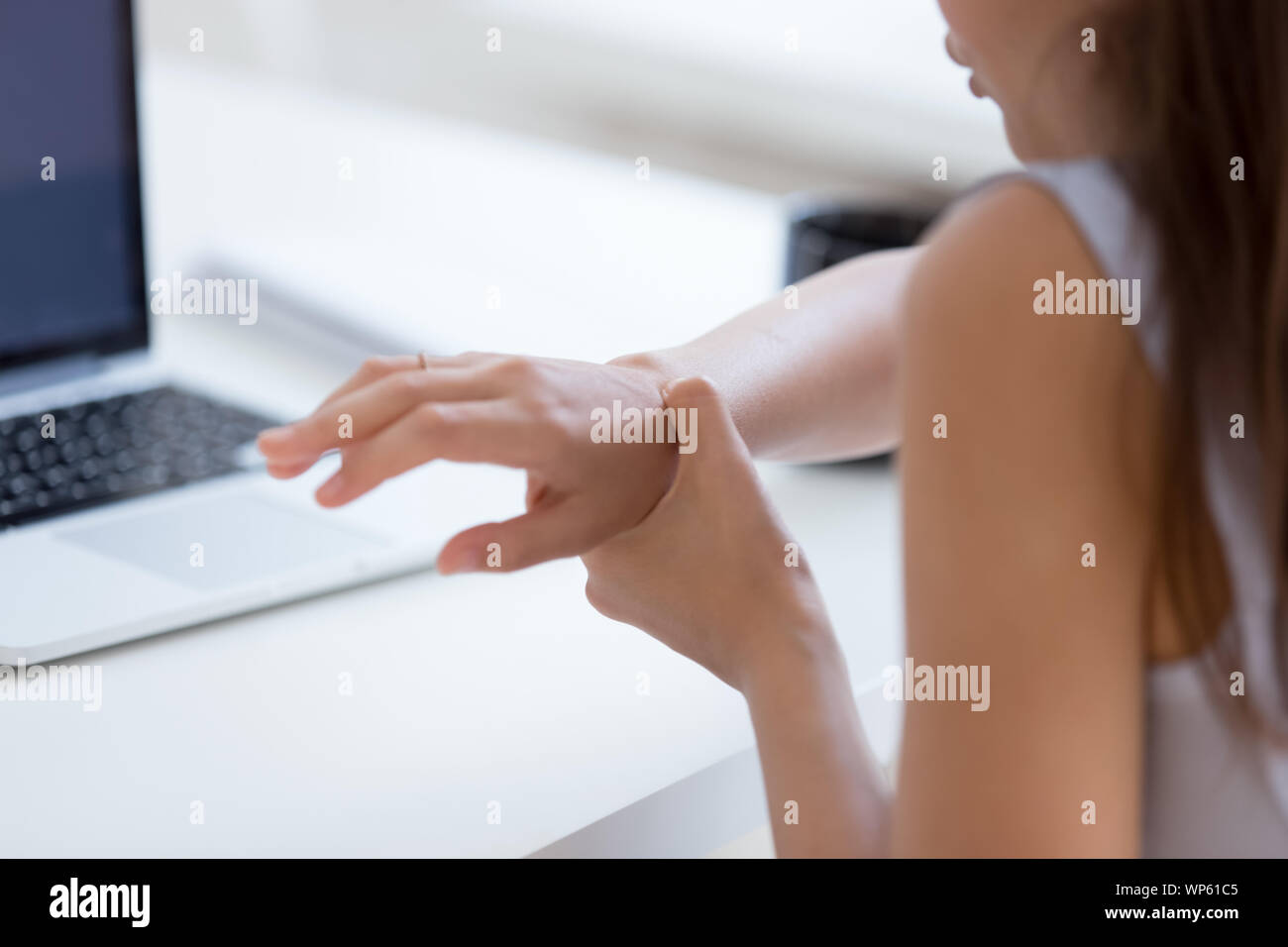 Hurt woman worker massage wrist suffering from spasm Stock Photo