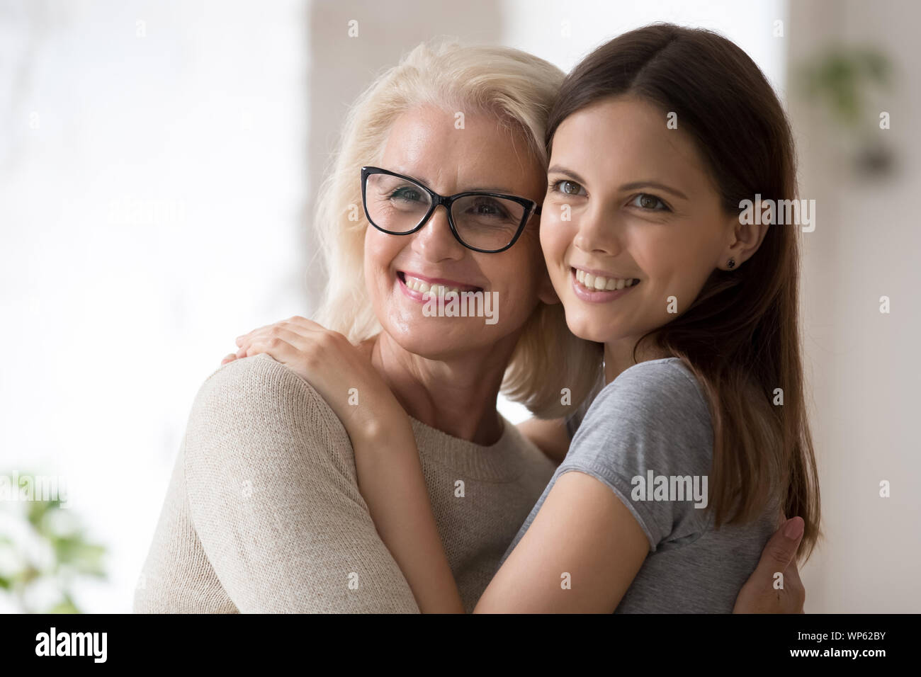 Smiling mother and daughter posing for picture together Stock Photo