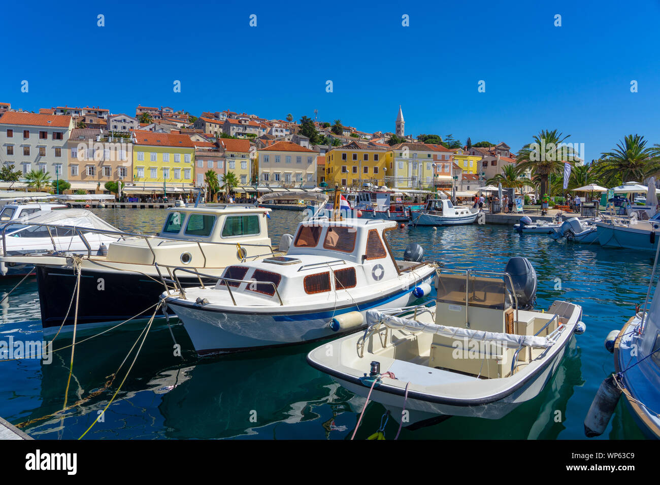 pier dock with boats in mali losinj island port croatia with colorful buildings Stock Photo