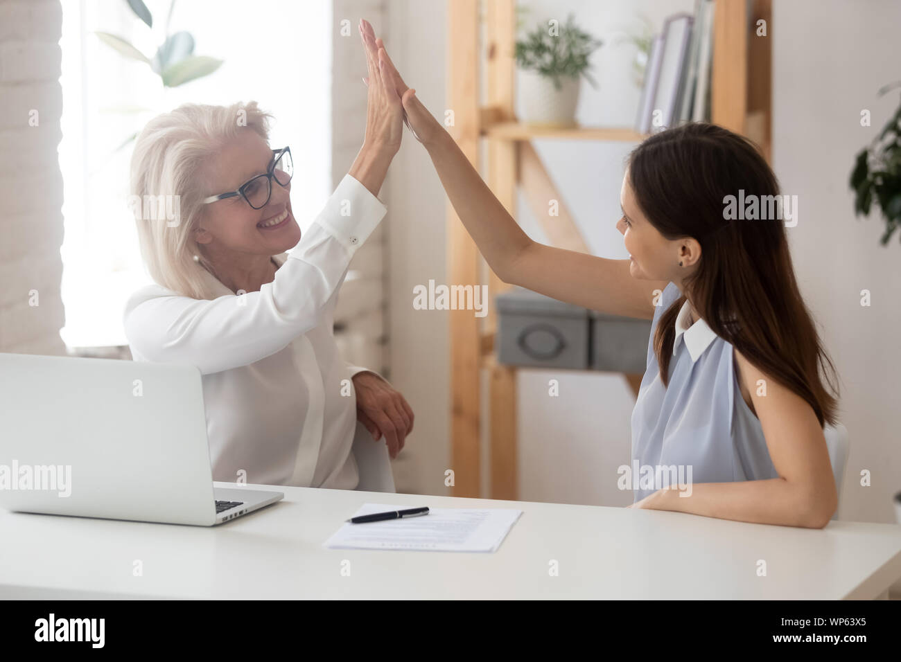 Happy female employee give high five celebrating success Stock Photo ...