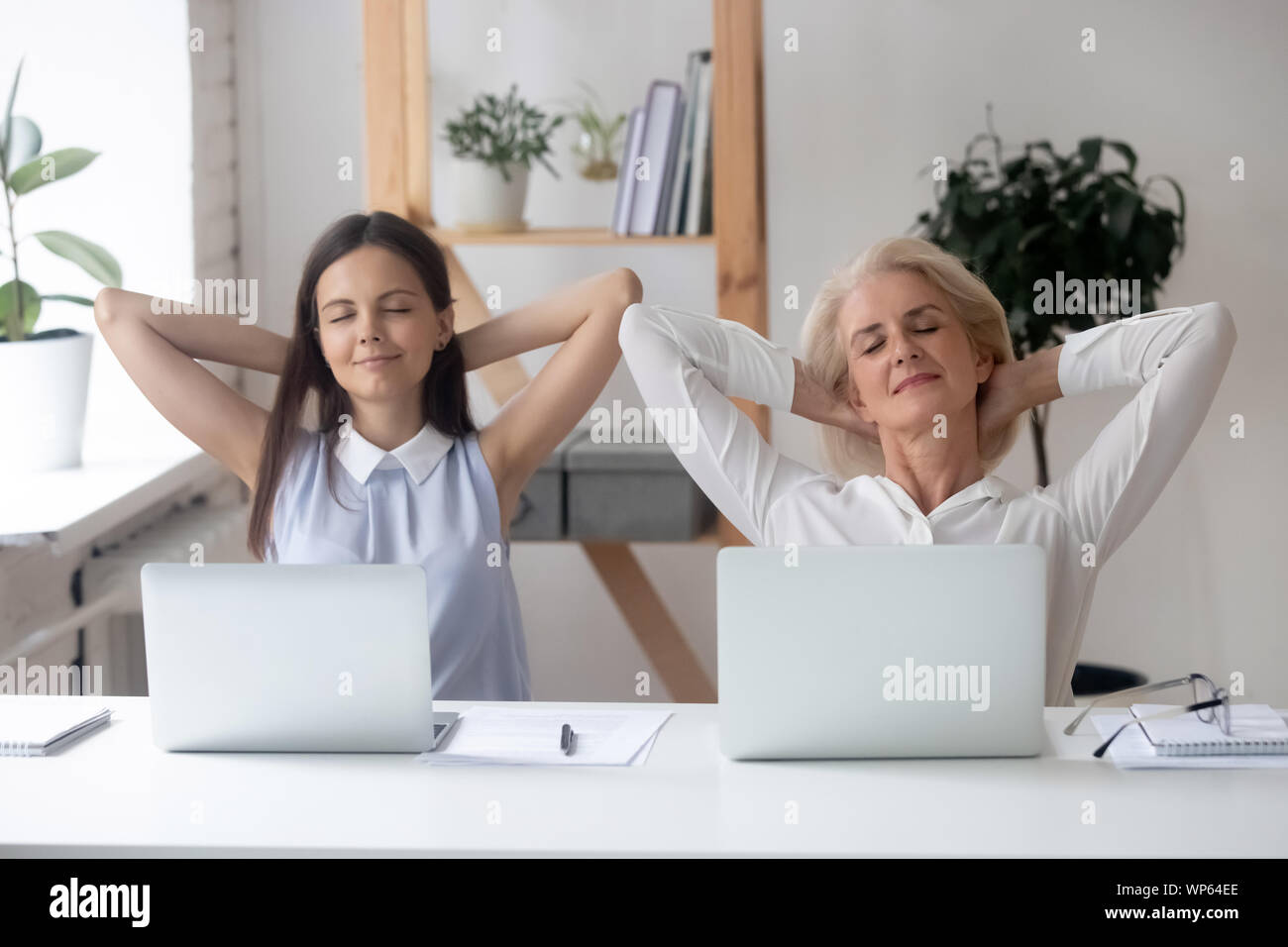 Female employees have break relaxing at workplace dreaming Stock Photo