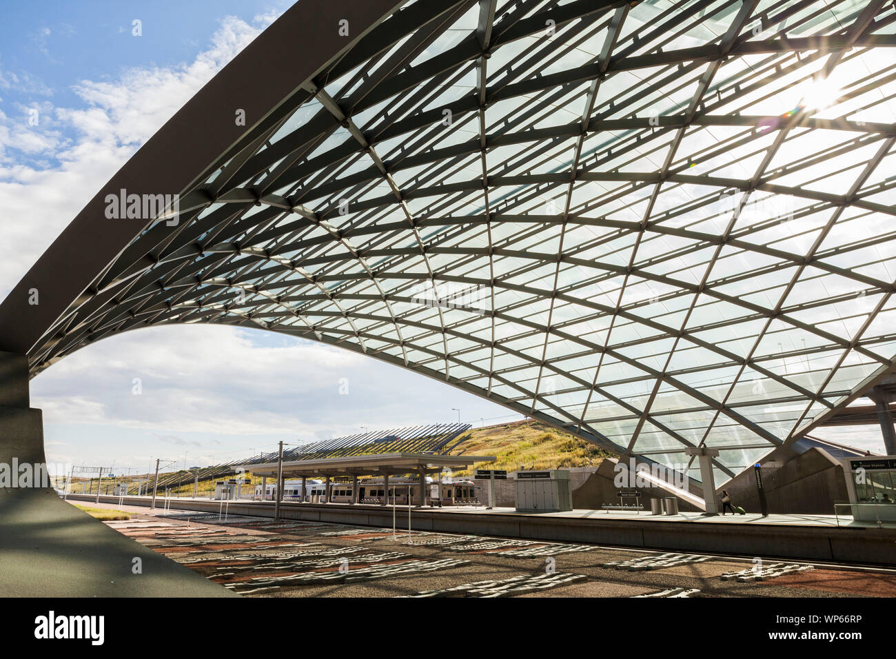 A traveler walks out to the light rail train, bound for Union Station
