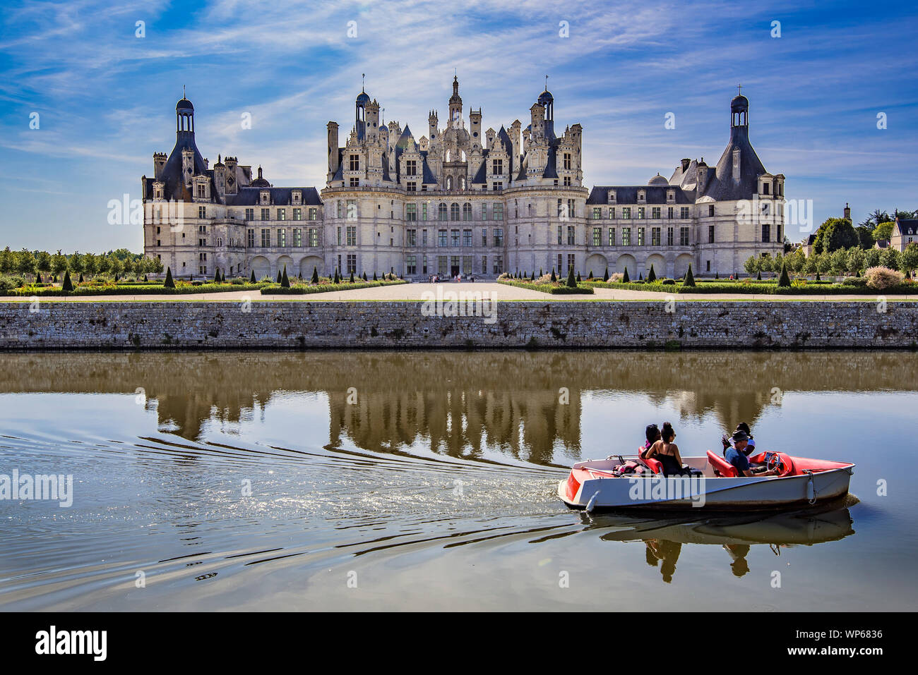 Chambord Castle with some people boating on the canal that surrounds it Stock Photo
